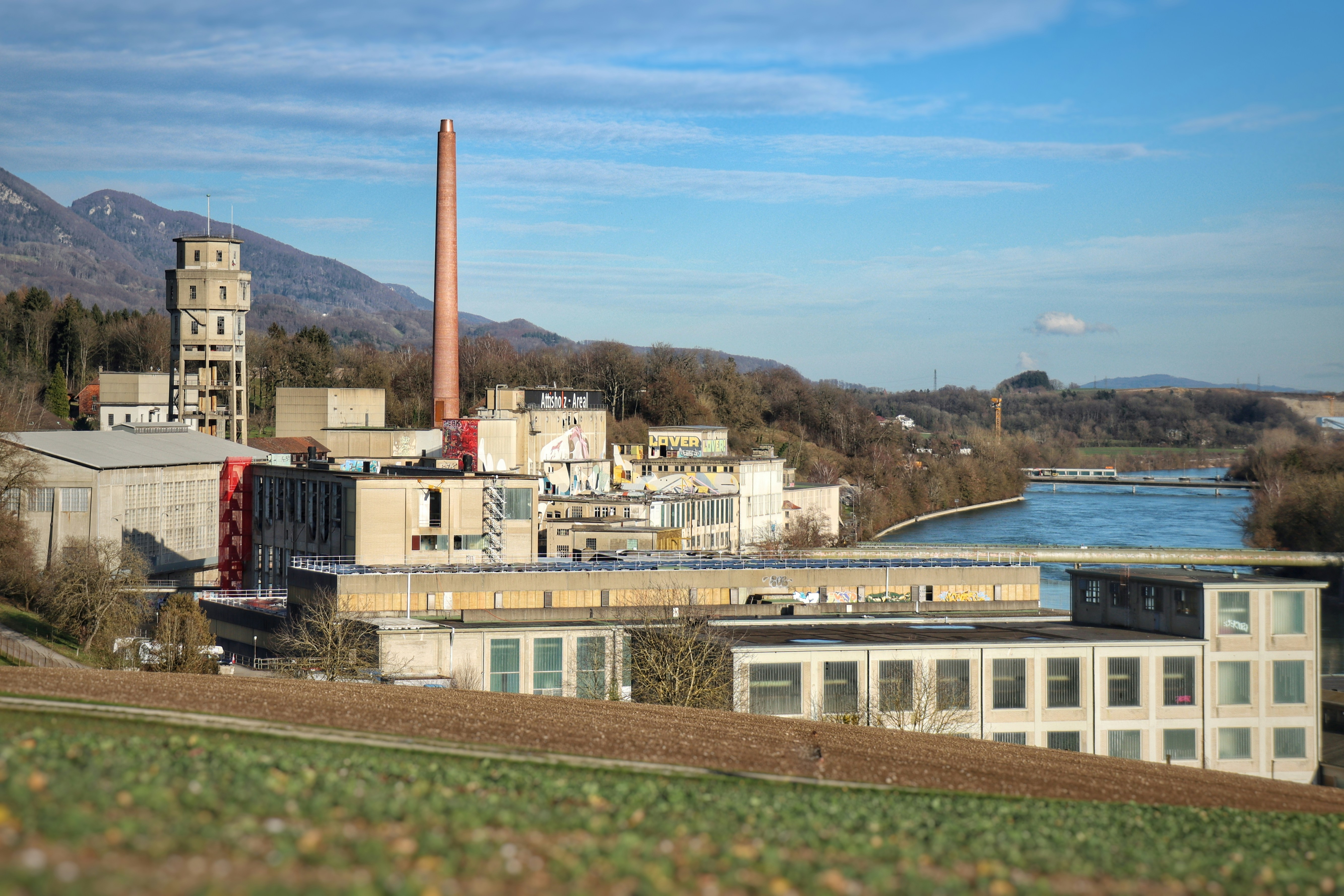 A view of a factory with a river in the background