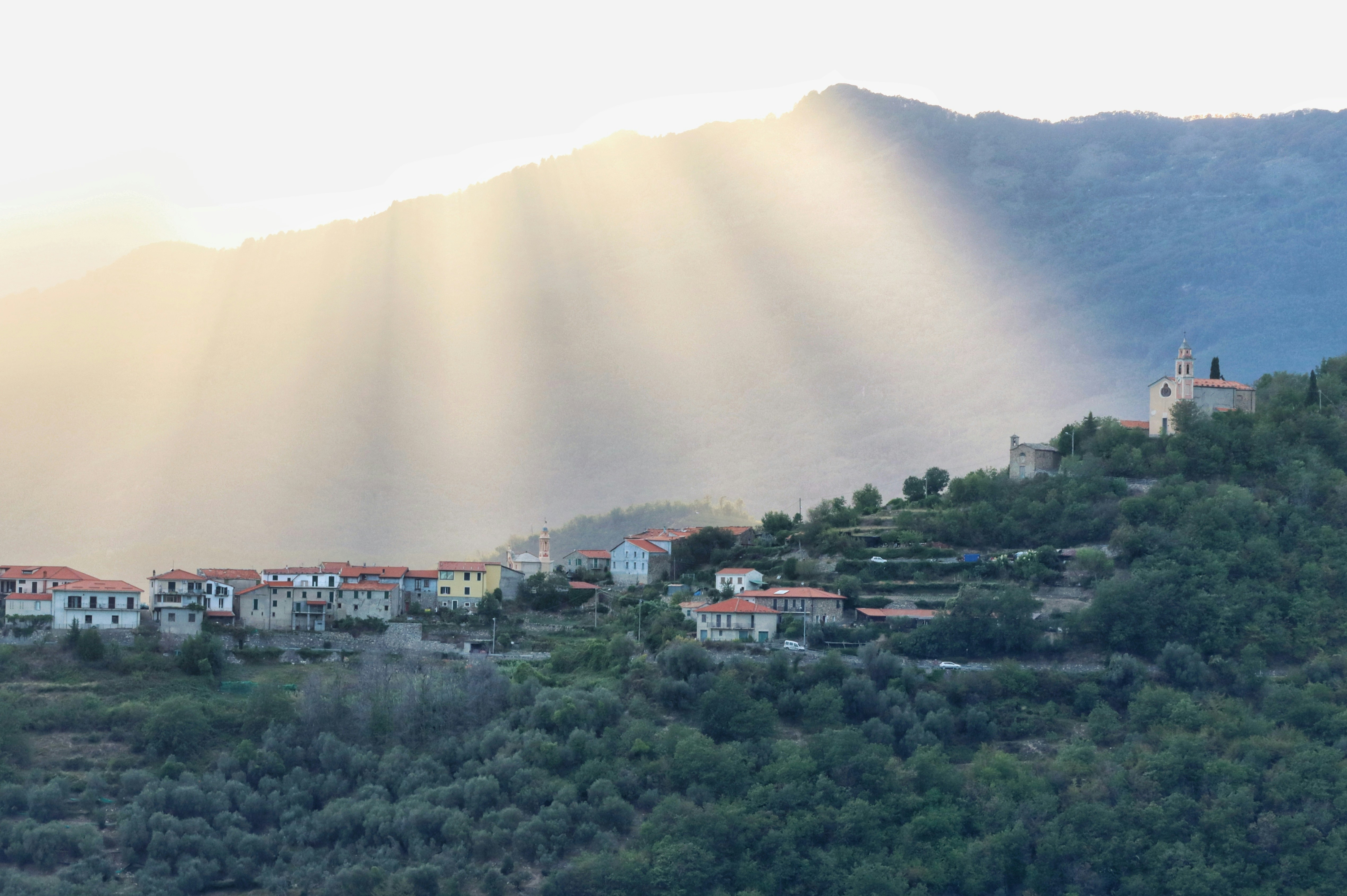 El sol brilla a través de las nubes sobre un pueblo