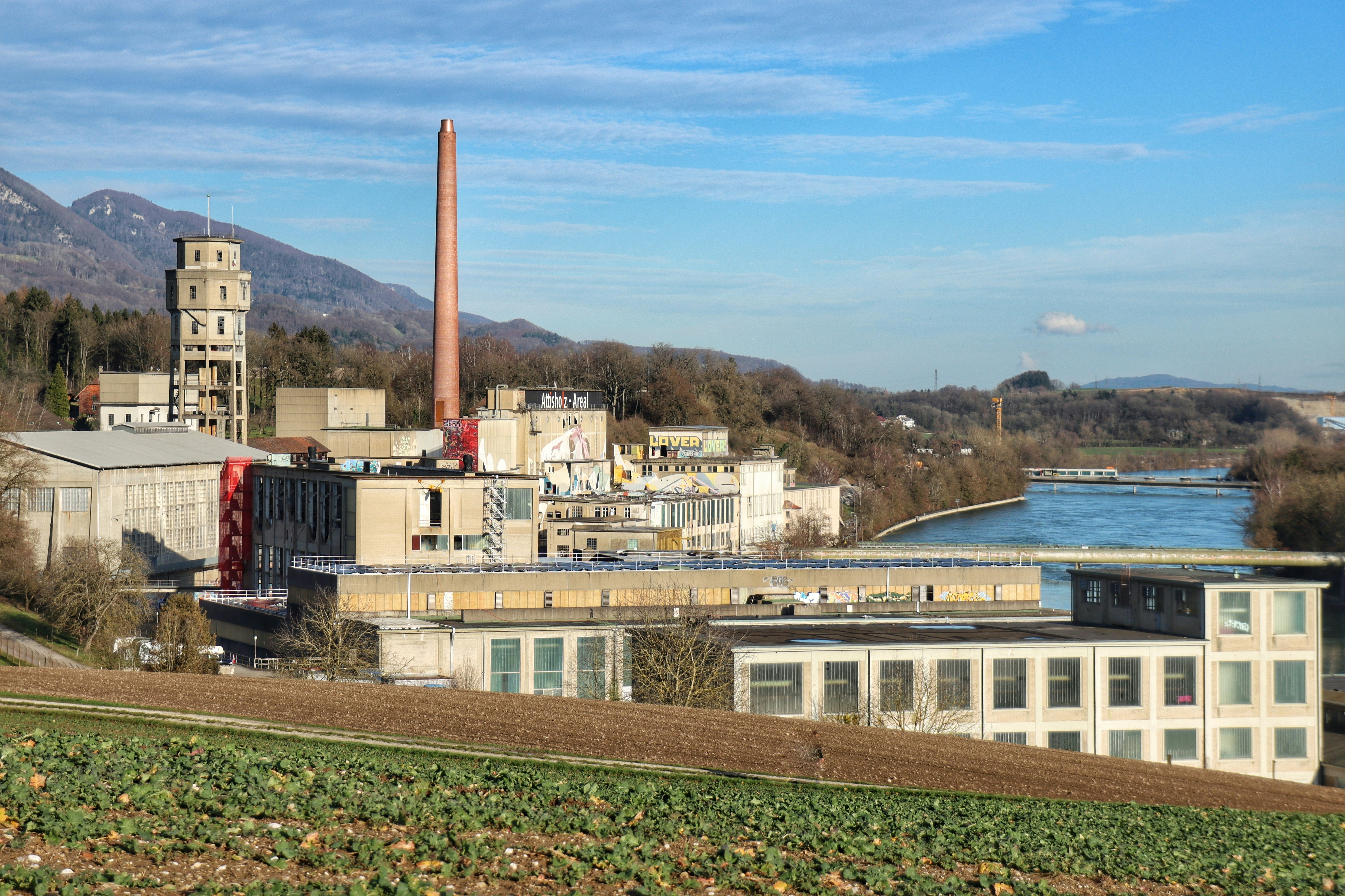 A view of a factory with a river in the background