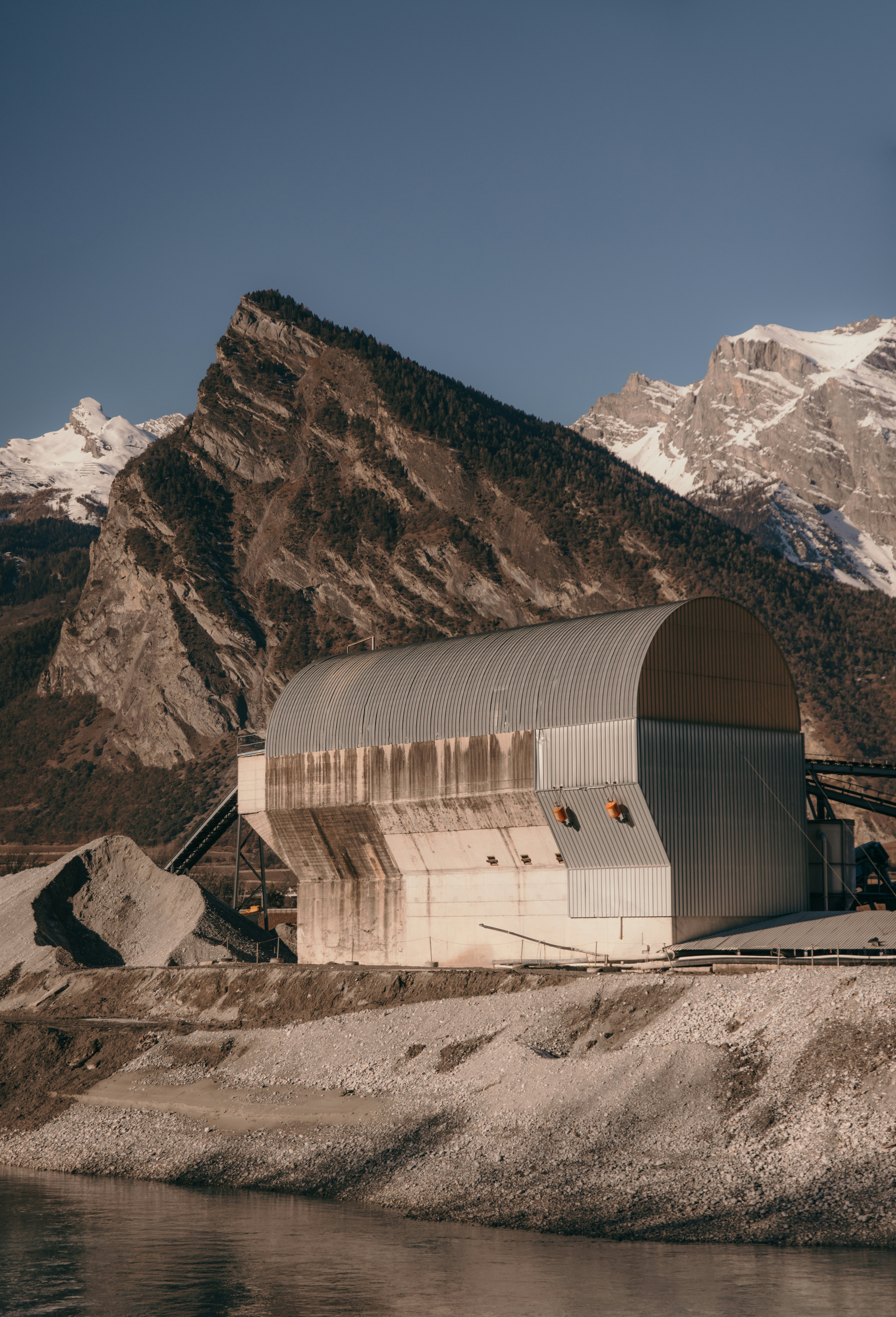 A large building sitting on top of a mountain next to a body of water ...
