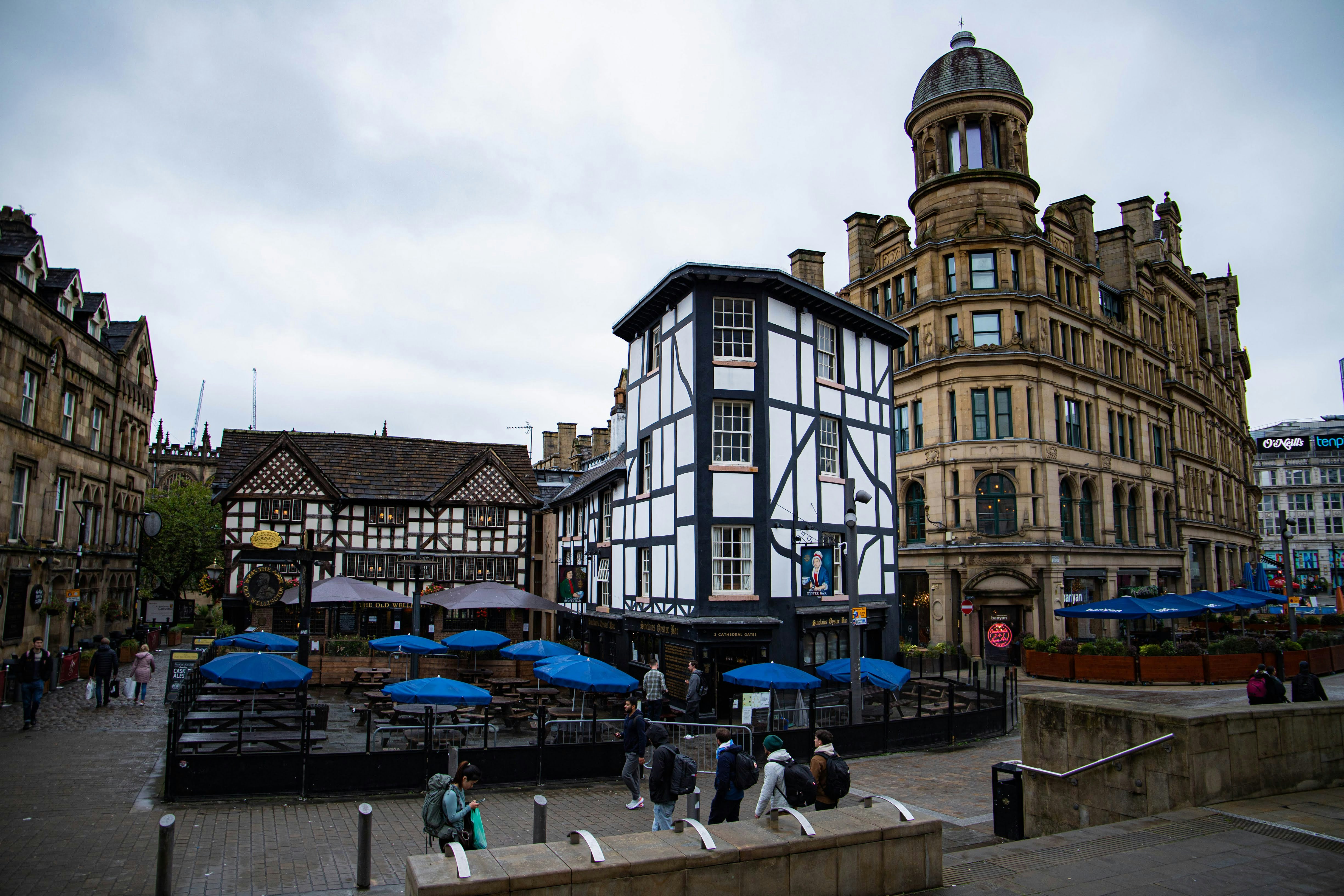 Un groupe de personnes marchant dans une rue à côté de grands immeubles
