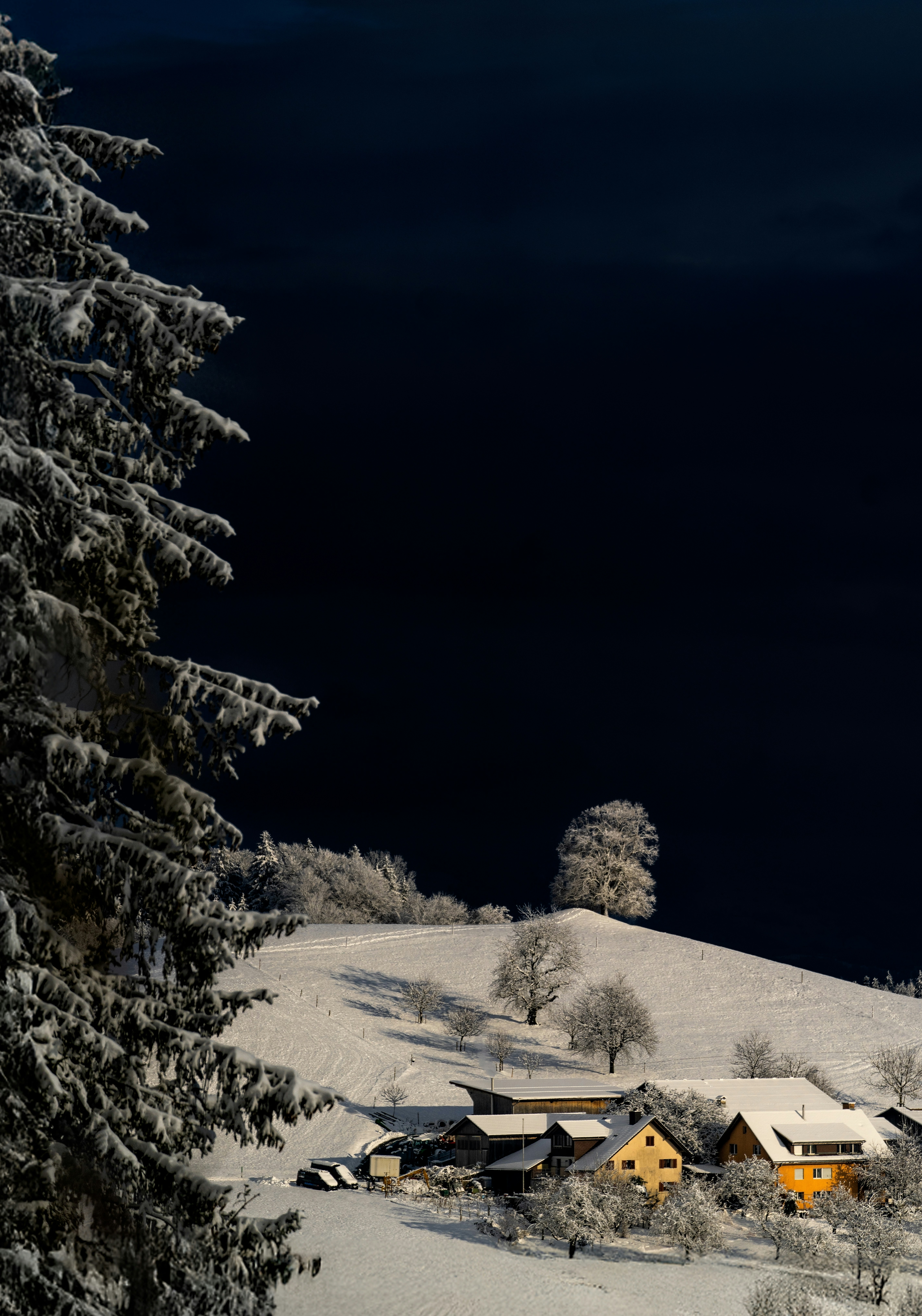 A snow covered hill with a house on top of it