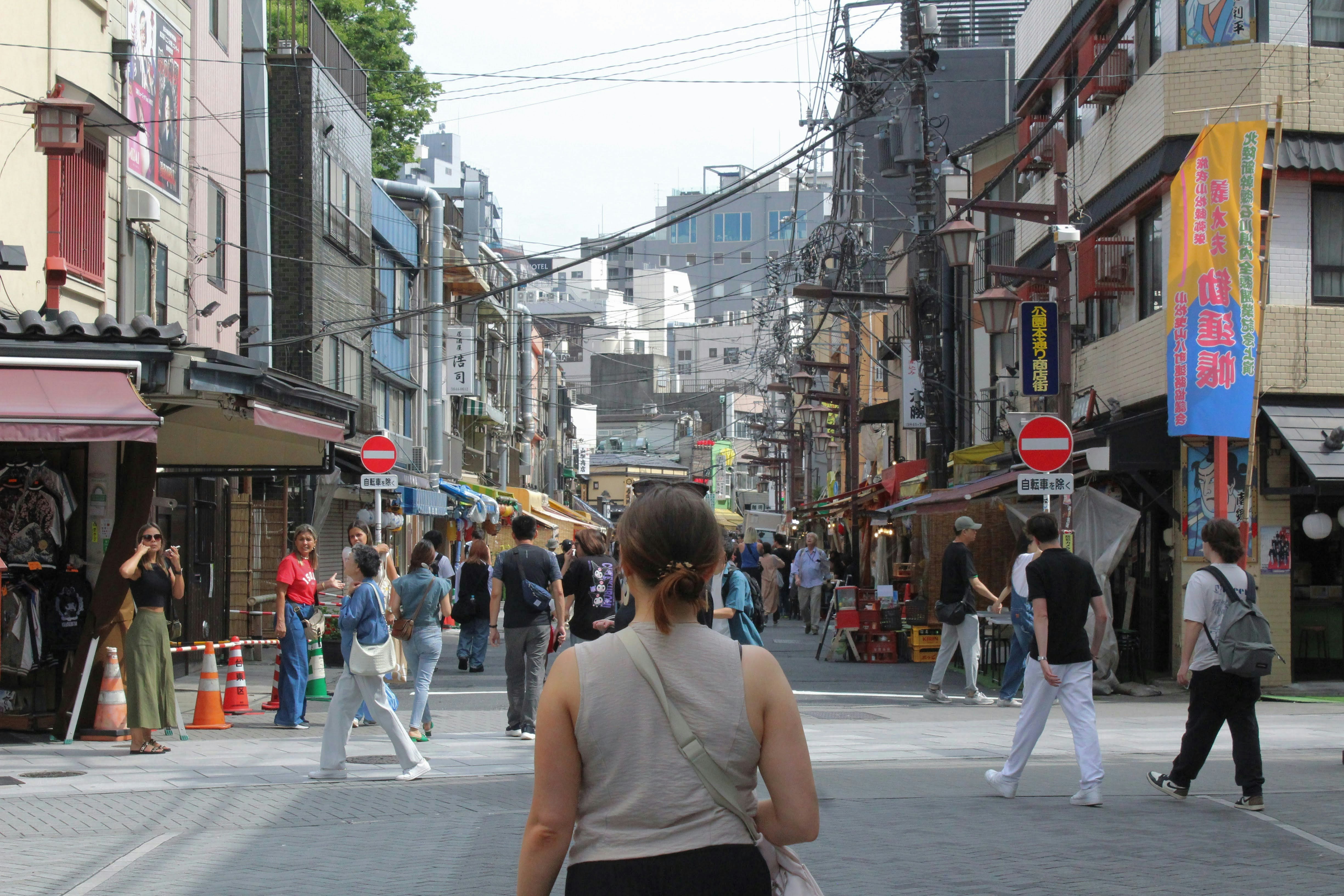 A group of people walking down a street next to tall buildings
