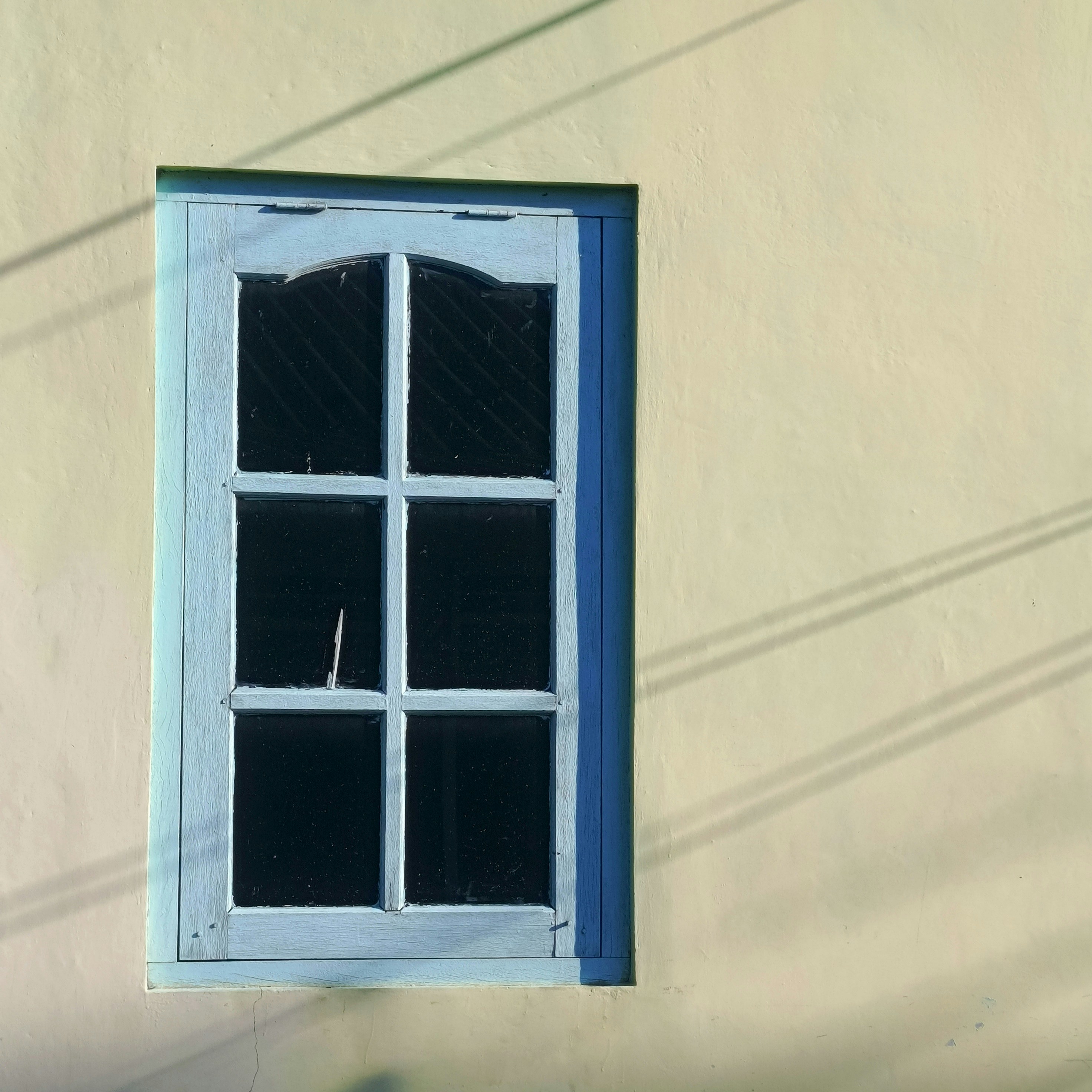 A blue window on the side of a building