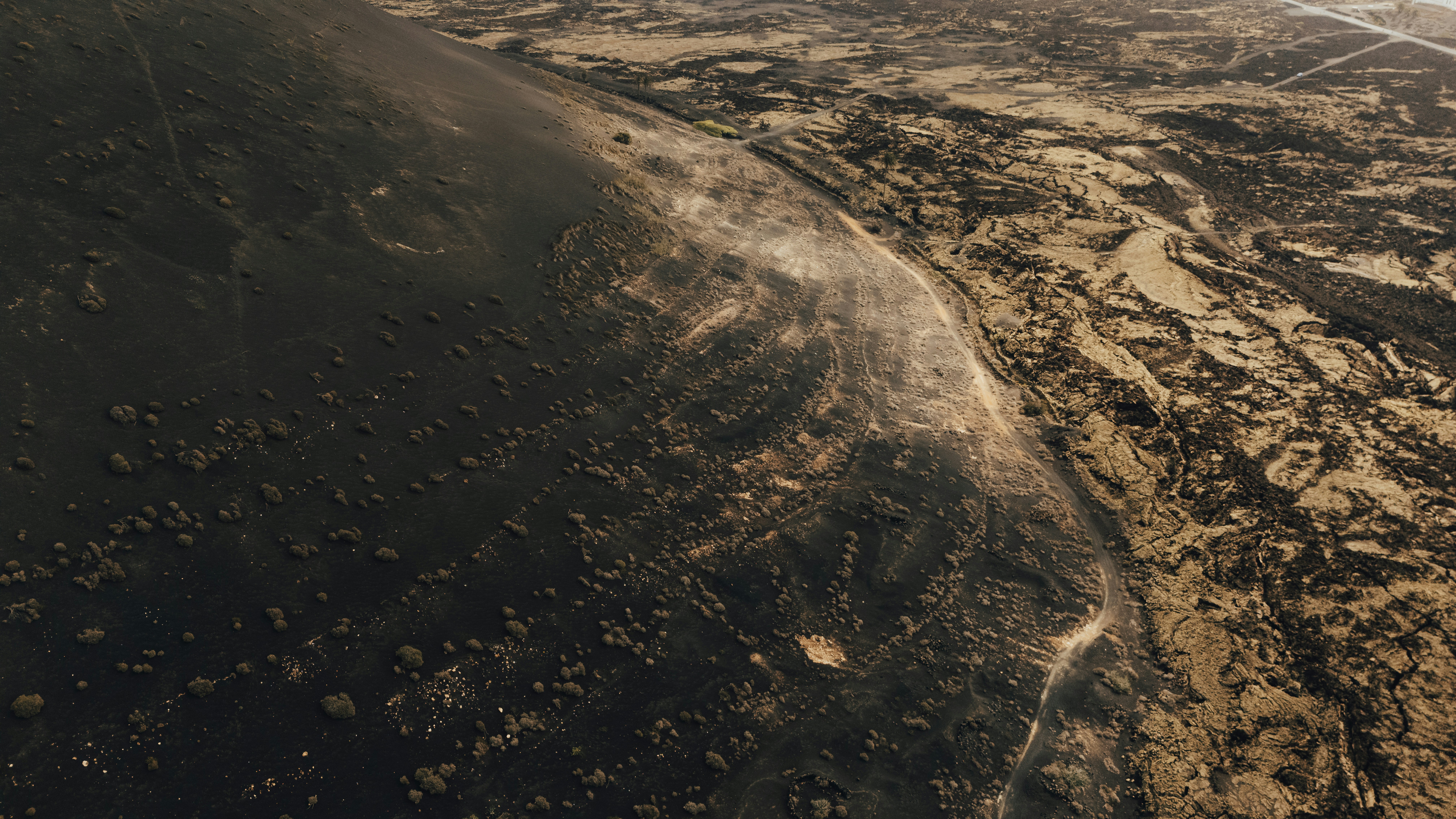 An aerial view of a dirt field and a body of water