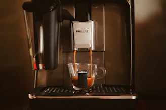 An espresso machine with a cup of coffee in front of it