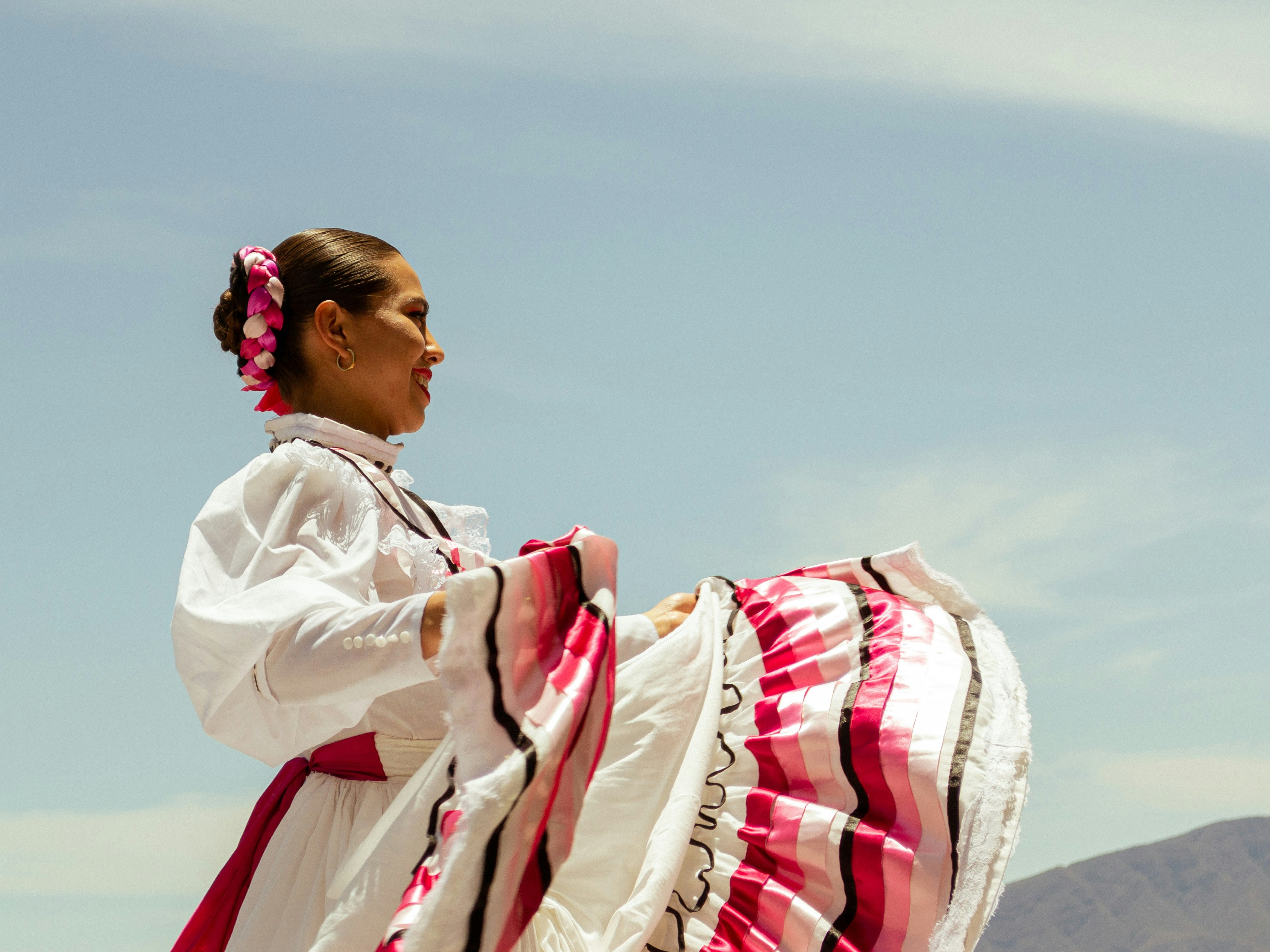 A woman in a white dress and a red and white skirt