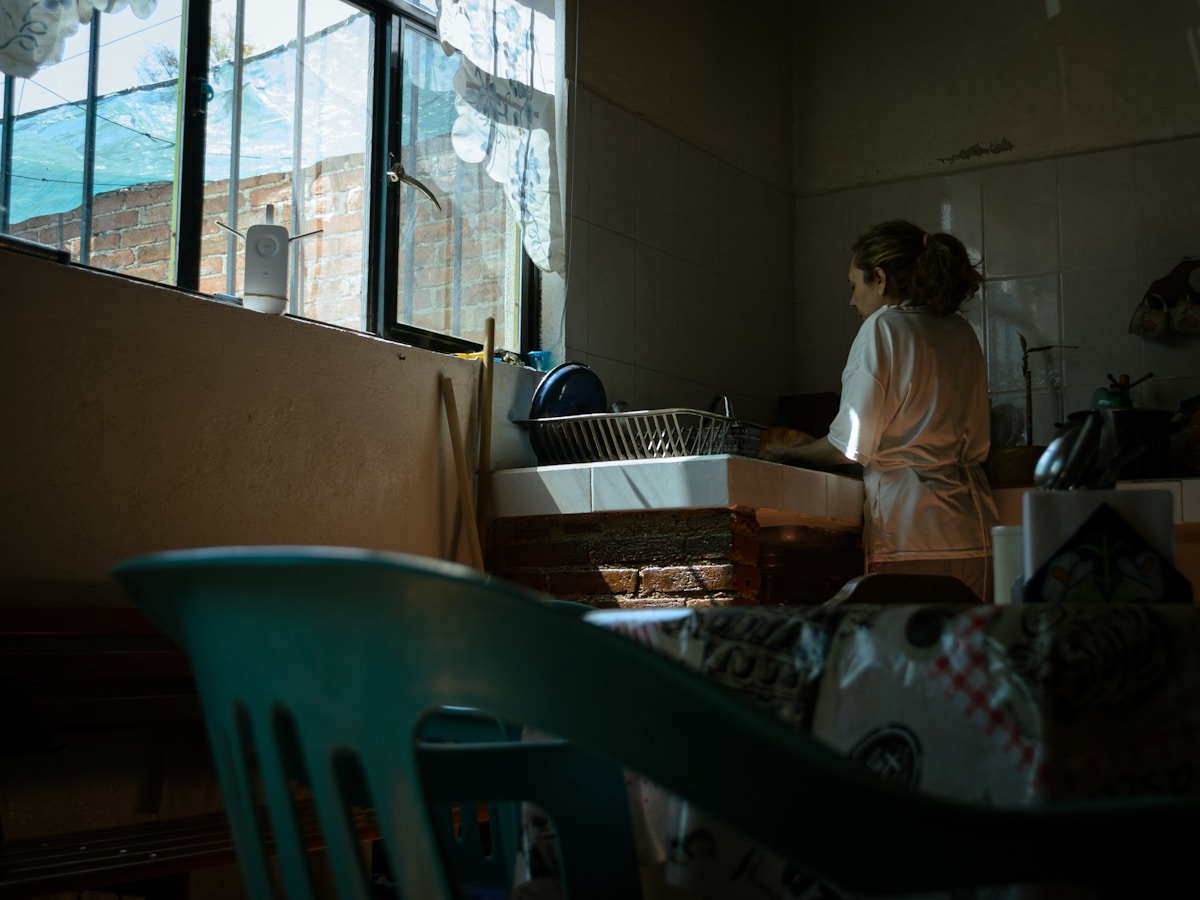 A woman standing in front of a window in a room