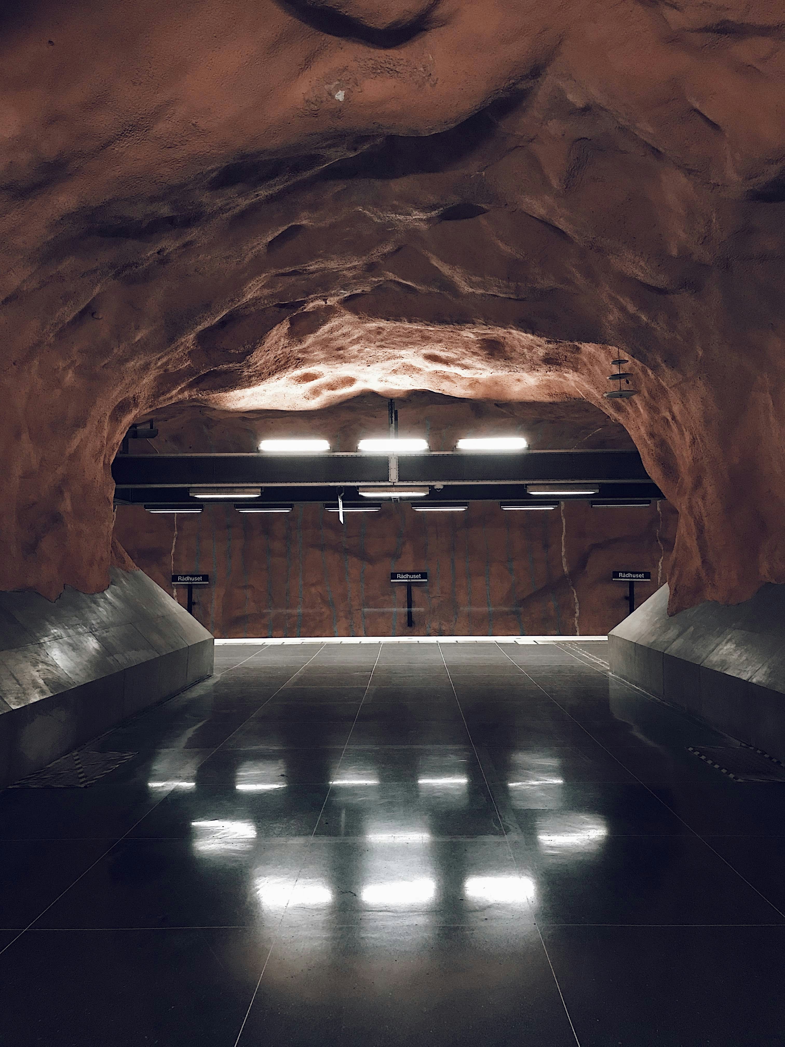 A tunnel with benches and lights inside of it