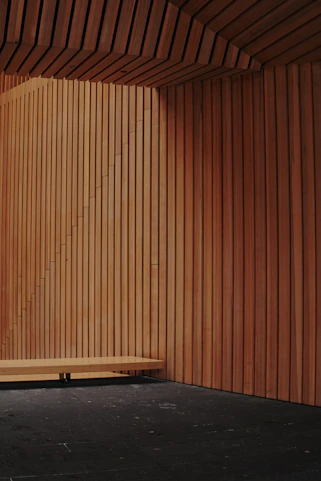 A room with a wooden wall and a wooden bench