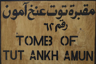 A wooden sign with arabic writing on it