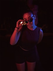 A woman in a black top is holding a cell phone