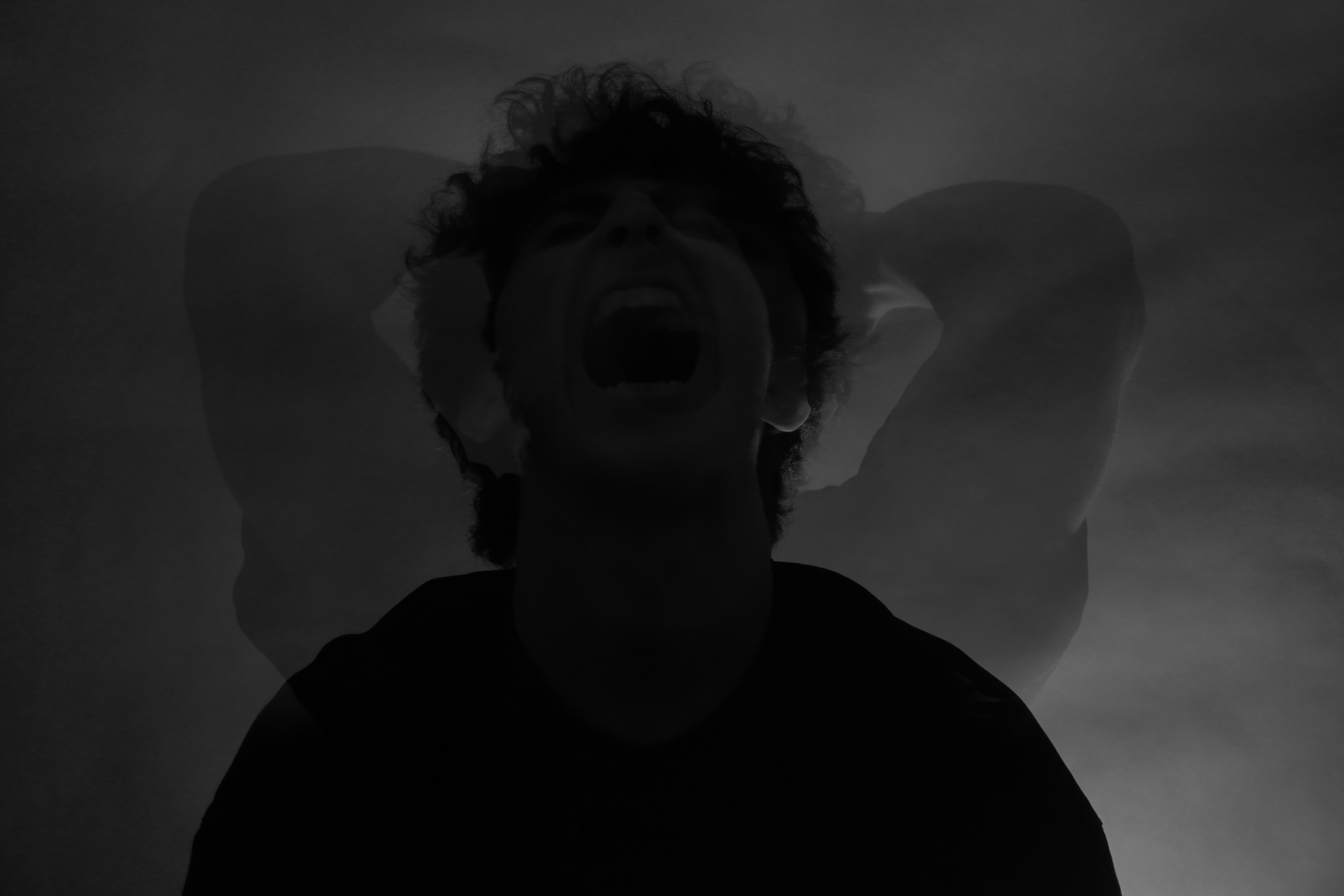 A man singing into a microphone in a dark room