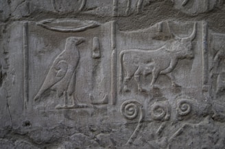 A close up of a stone wall with animals and birds