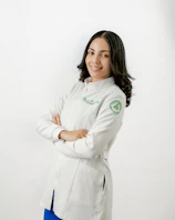 A woman in a white coat is posing for a picture