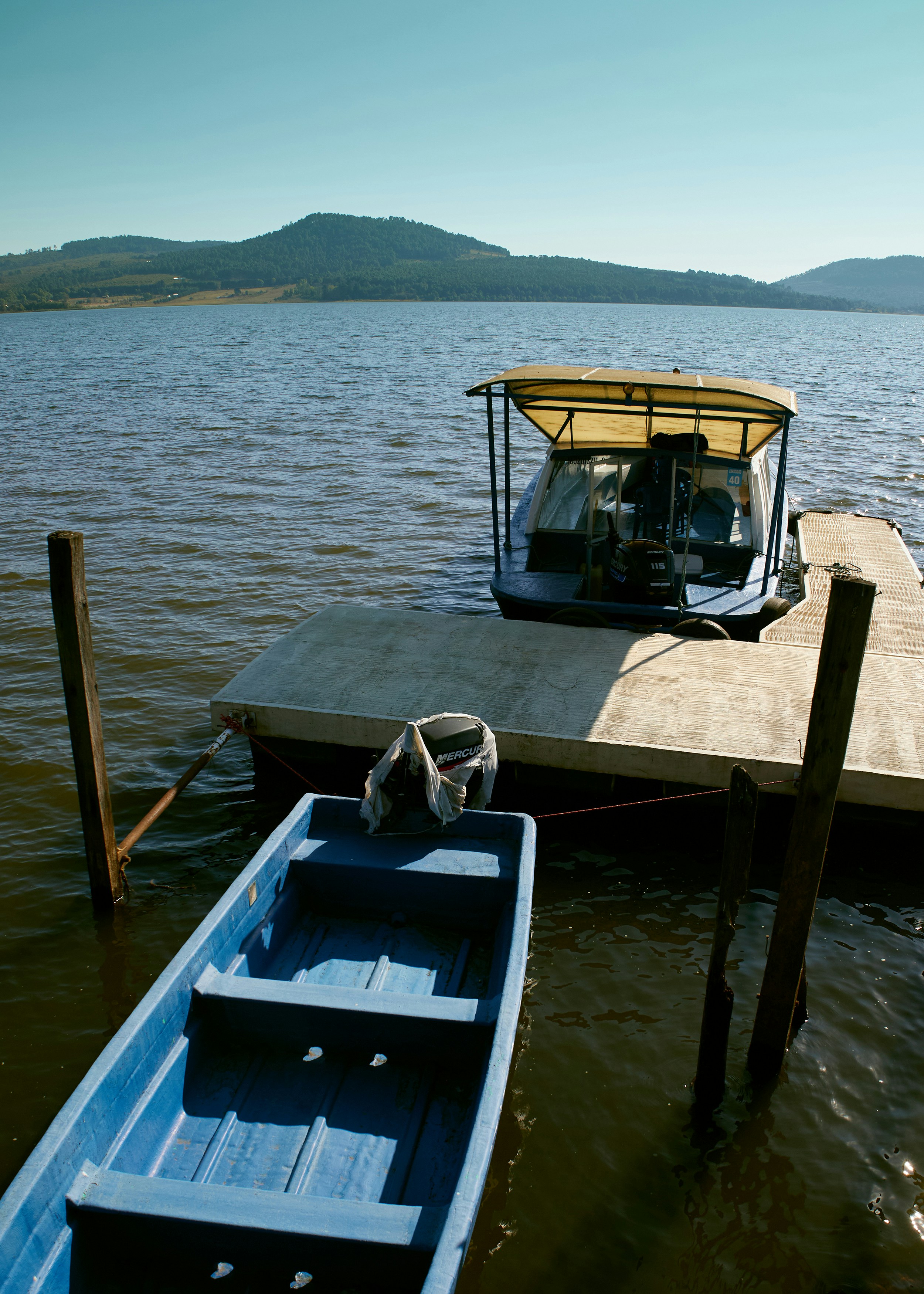 A small boat tied to a dock on a lake