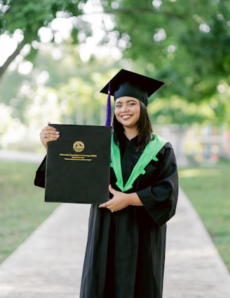 A woman in a cap and gown holding a diploma