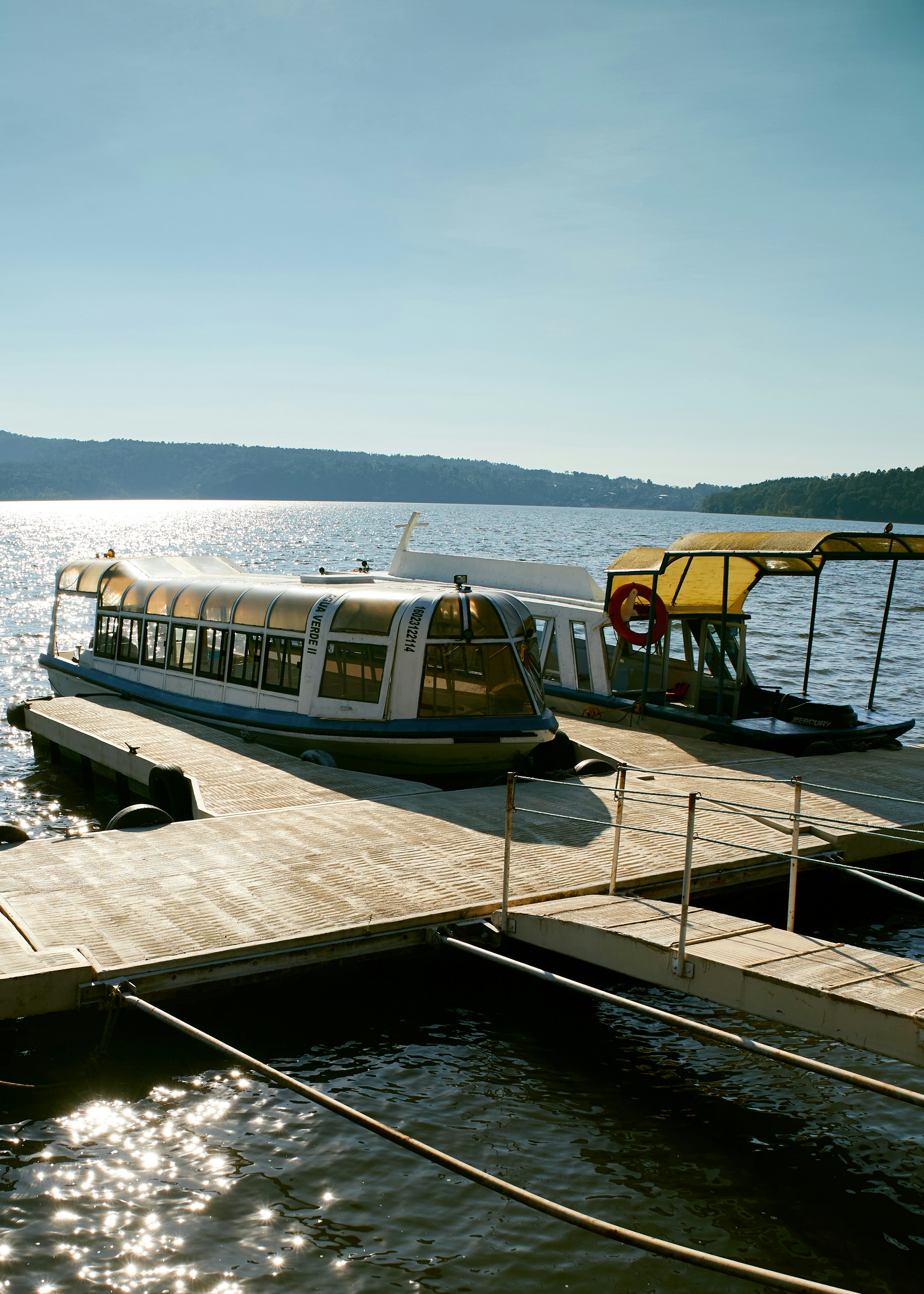 A boat docked at a pier on a lake