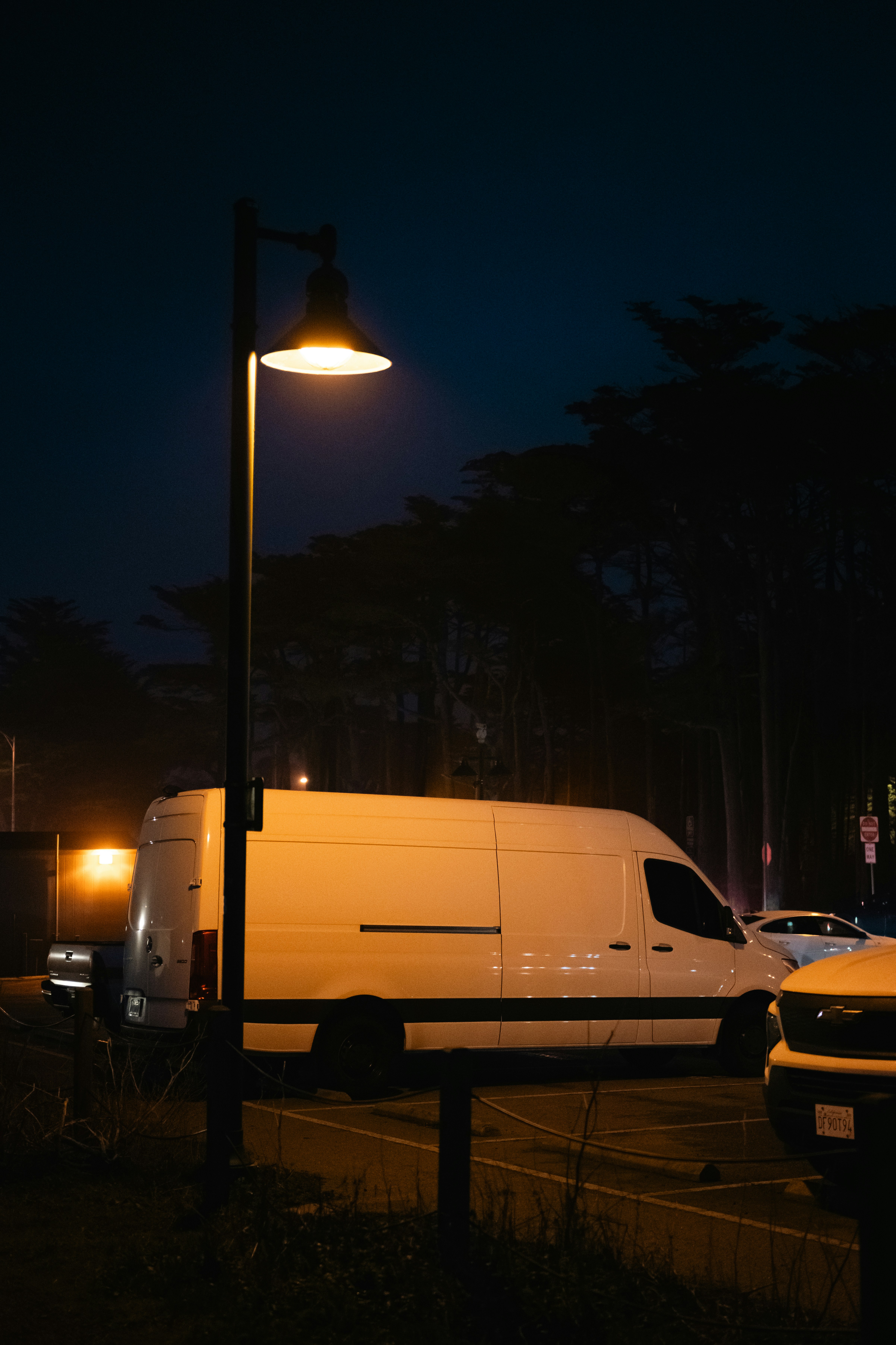 A white van parked in a parking lot at night photo – Free Car Image on ...