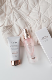 The contents of a white purse and a bottle of lotion