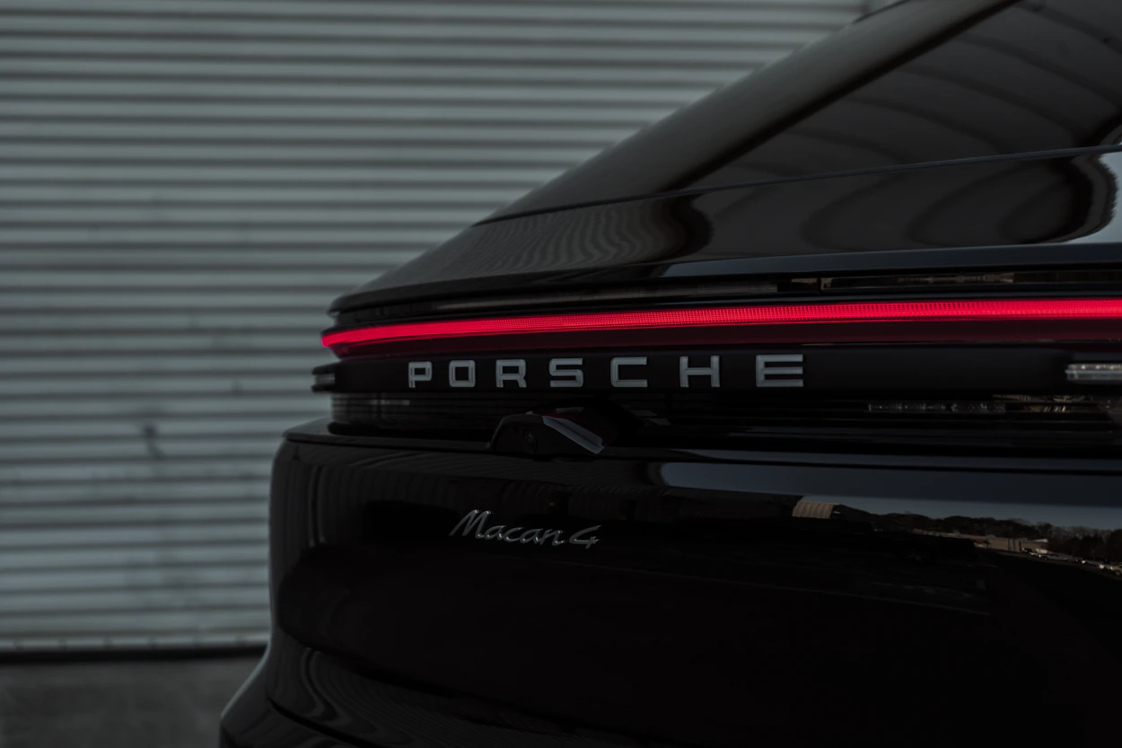 Black Porsche outside a garage