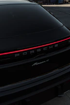 A black porsche parked in a parking lot
