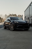 A black porsche suv parked in front of a building