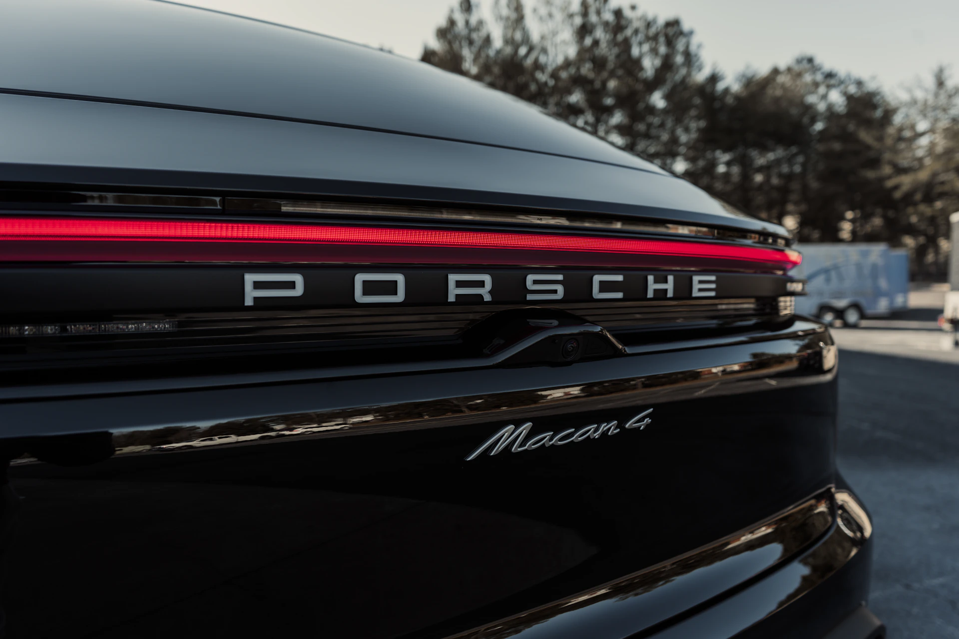 A close up of the tail lights of a black porsche