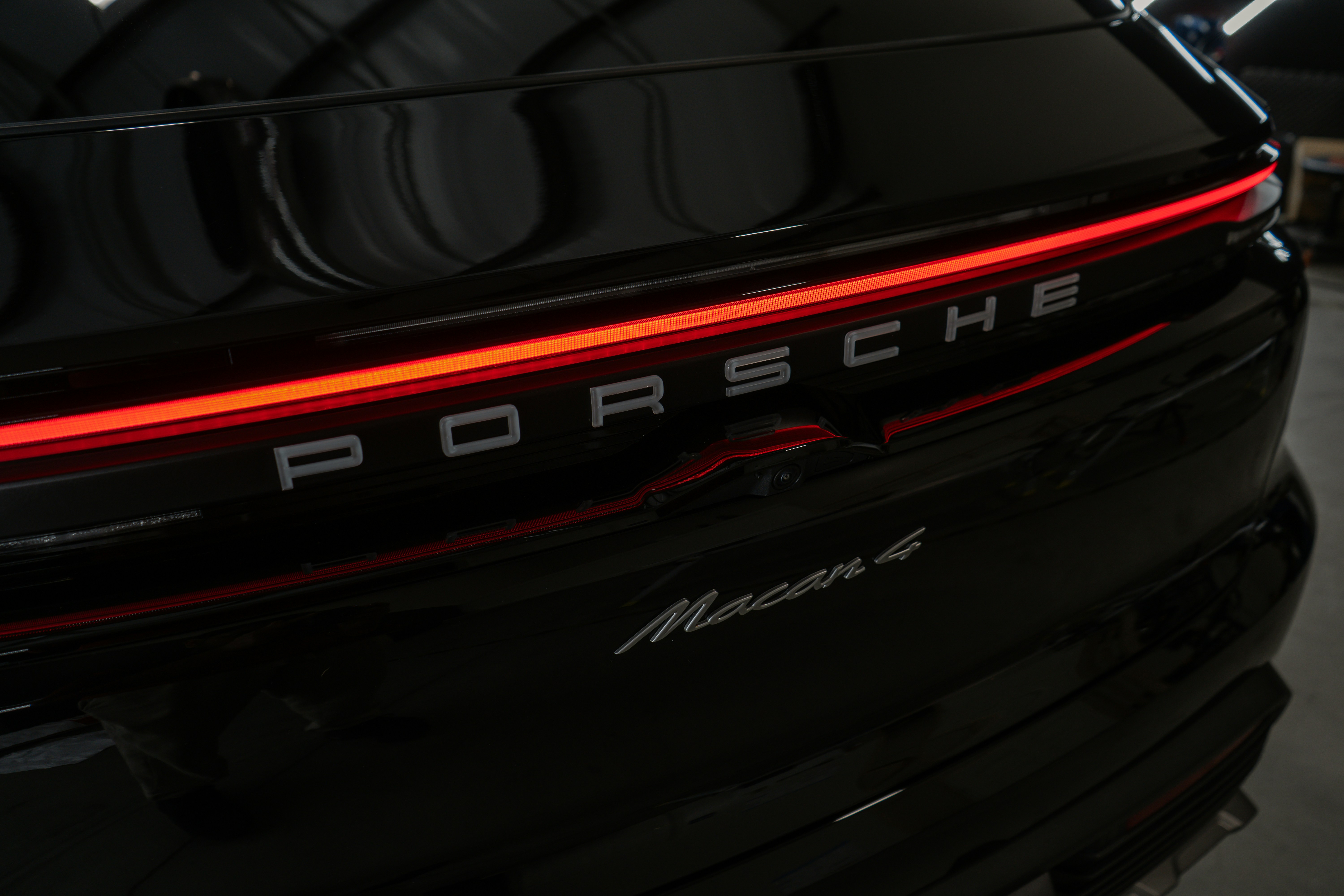 The back end of a porsche car parked in a garage