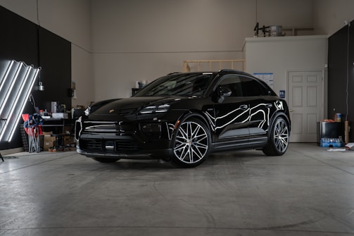 A black car parked inside of a garage