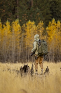 A man with a backpack is standing in a field