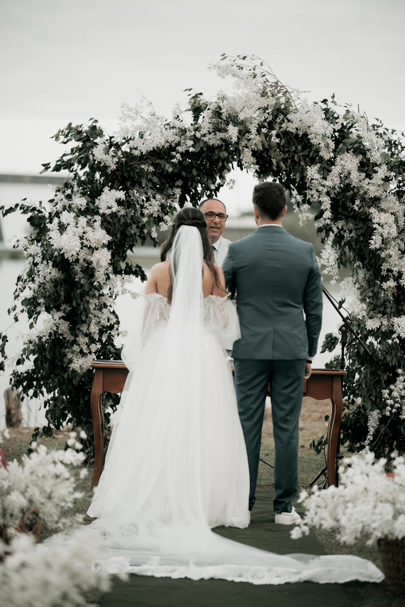 Bride and groom beneath a floral ceremony arch