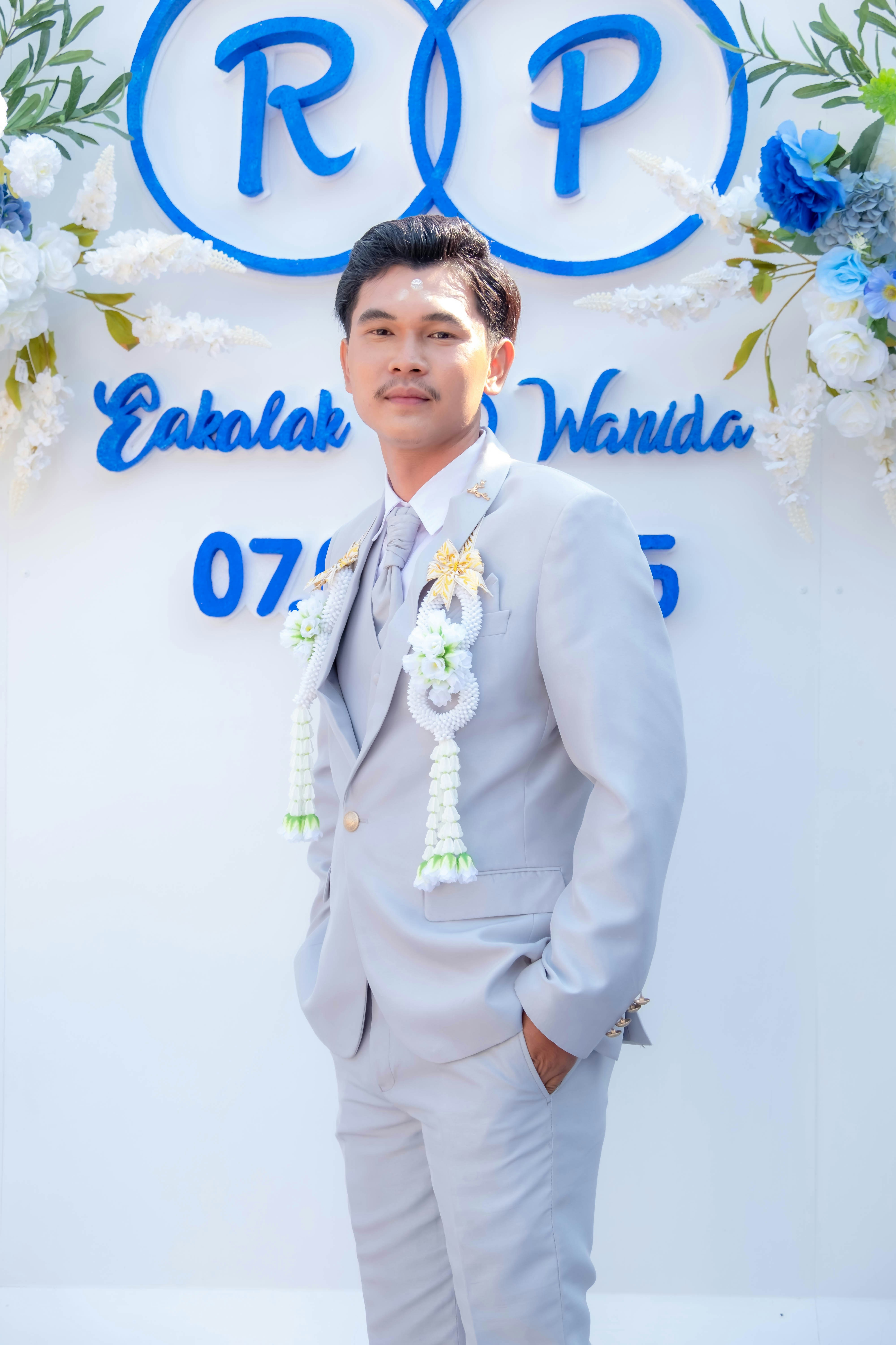 A man in a suit standing in front of a sign