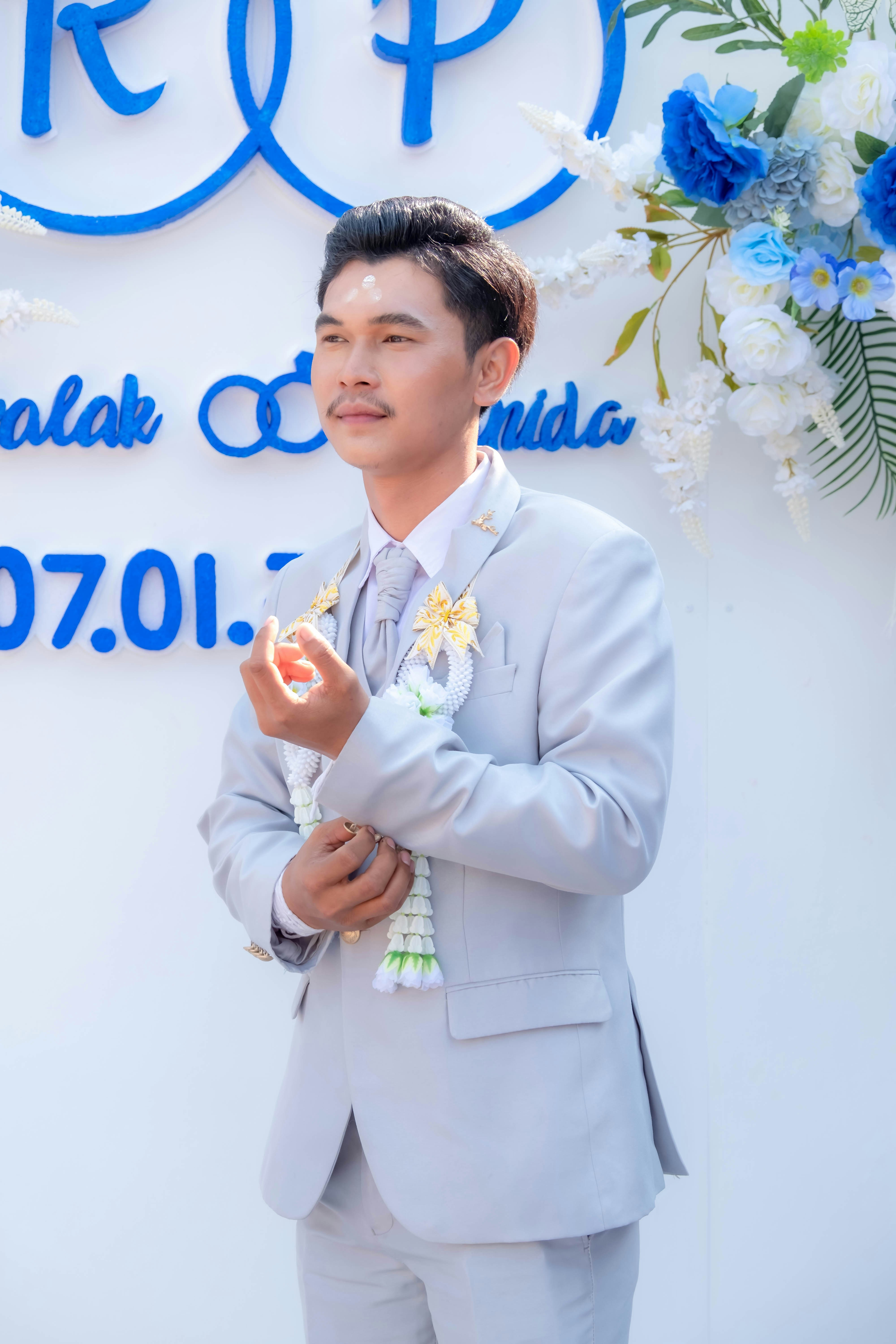 Seorang pria berjas berdiri di depan tanda