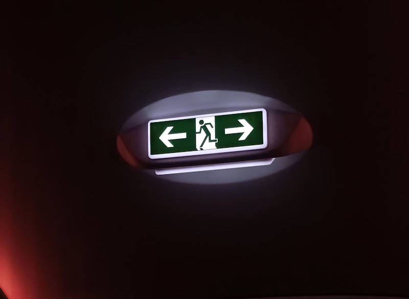 A green and white exit sign in a dark room
