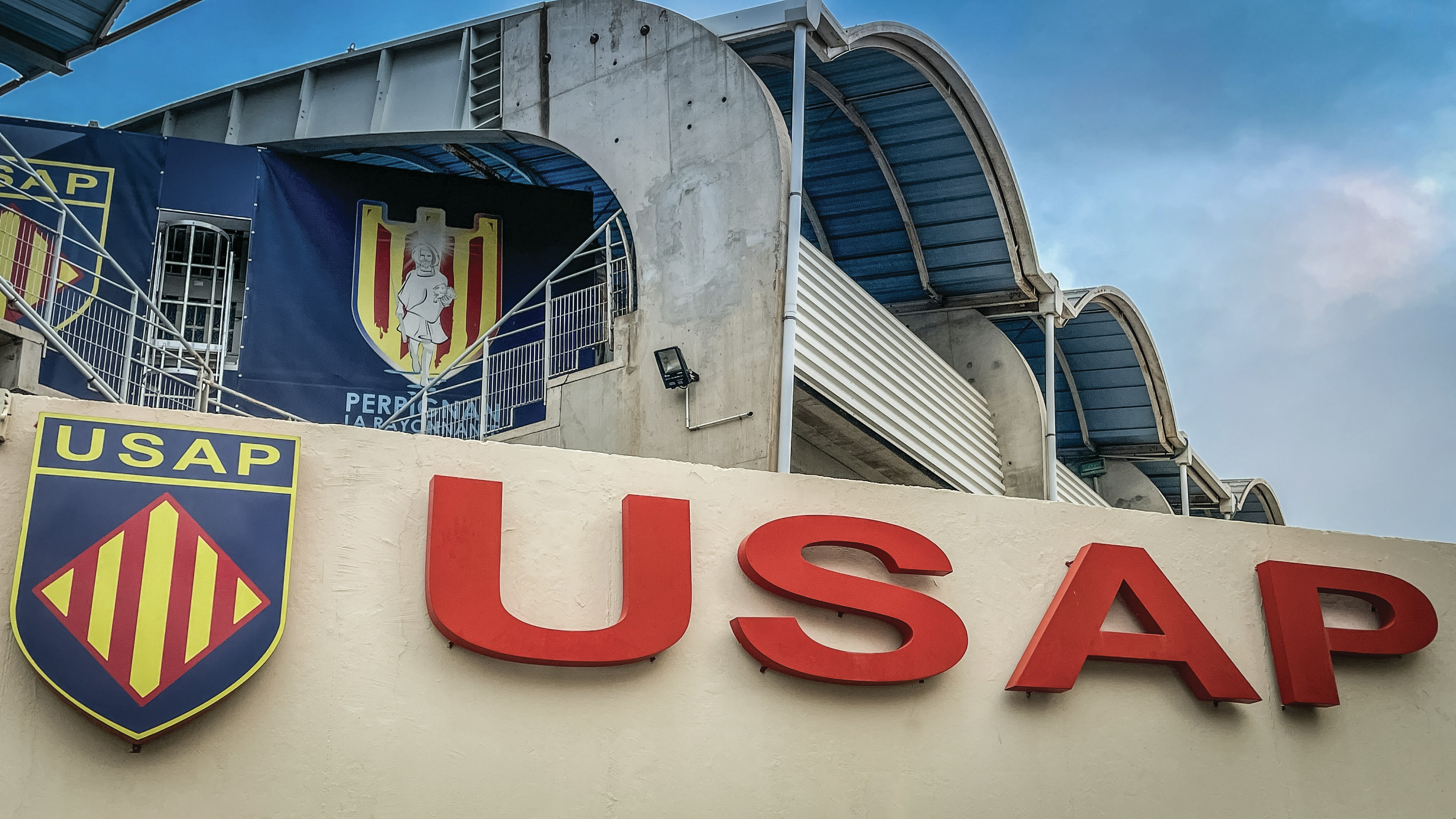 A sign that says usap with a building in the background