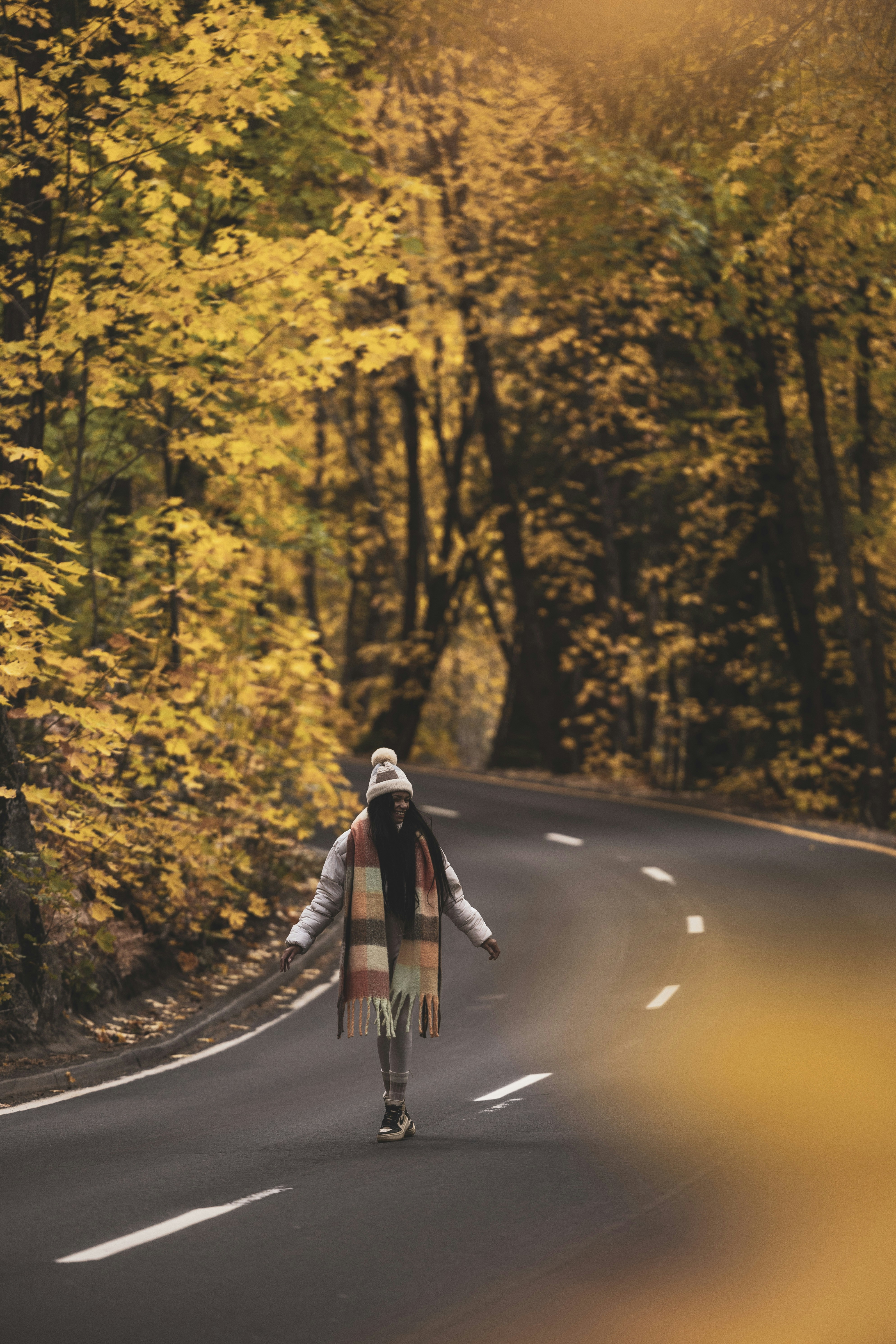 A woman riding a skateboard down a curvy road