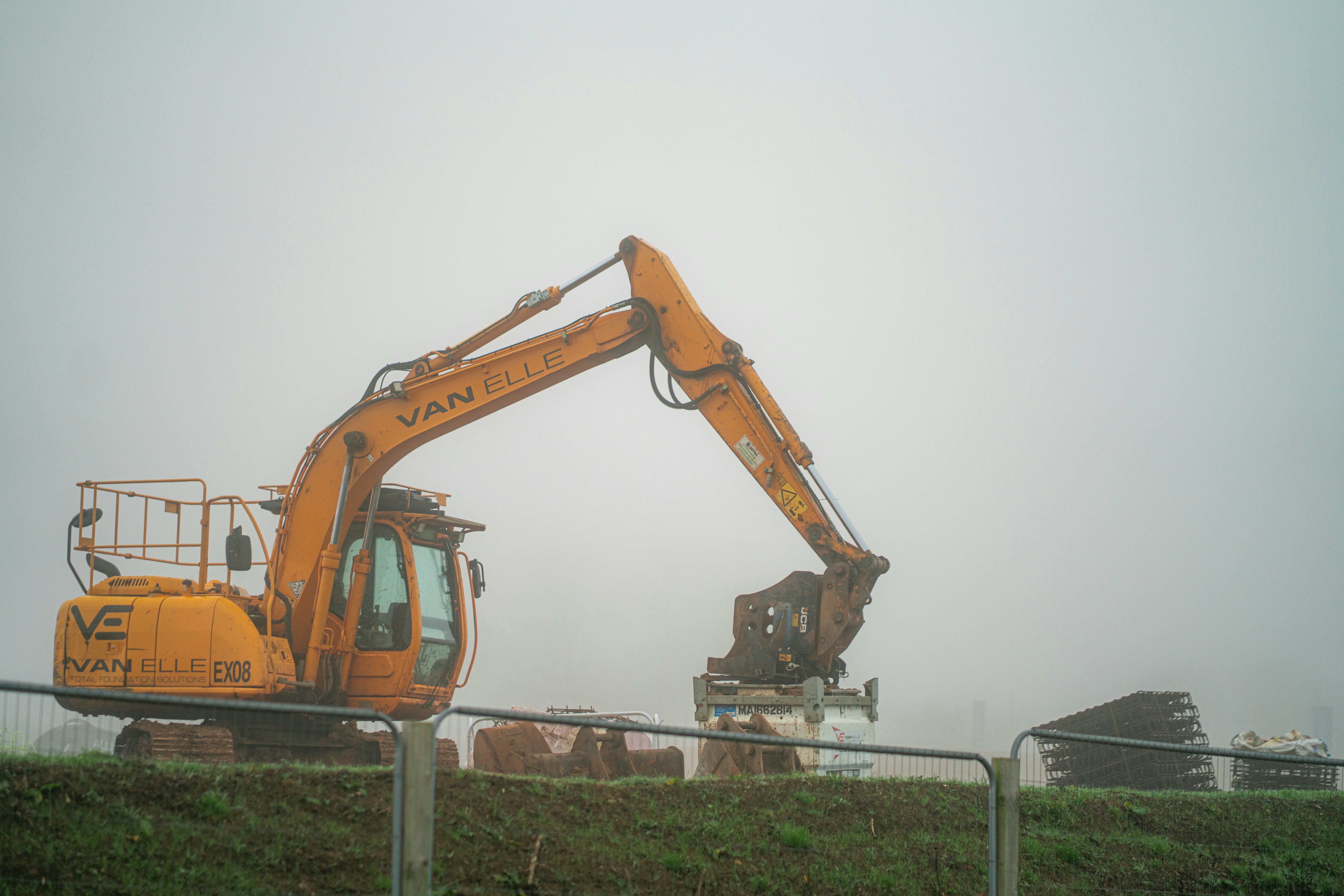 A construction vehicle is parked behind a fence