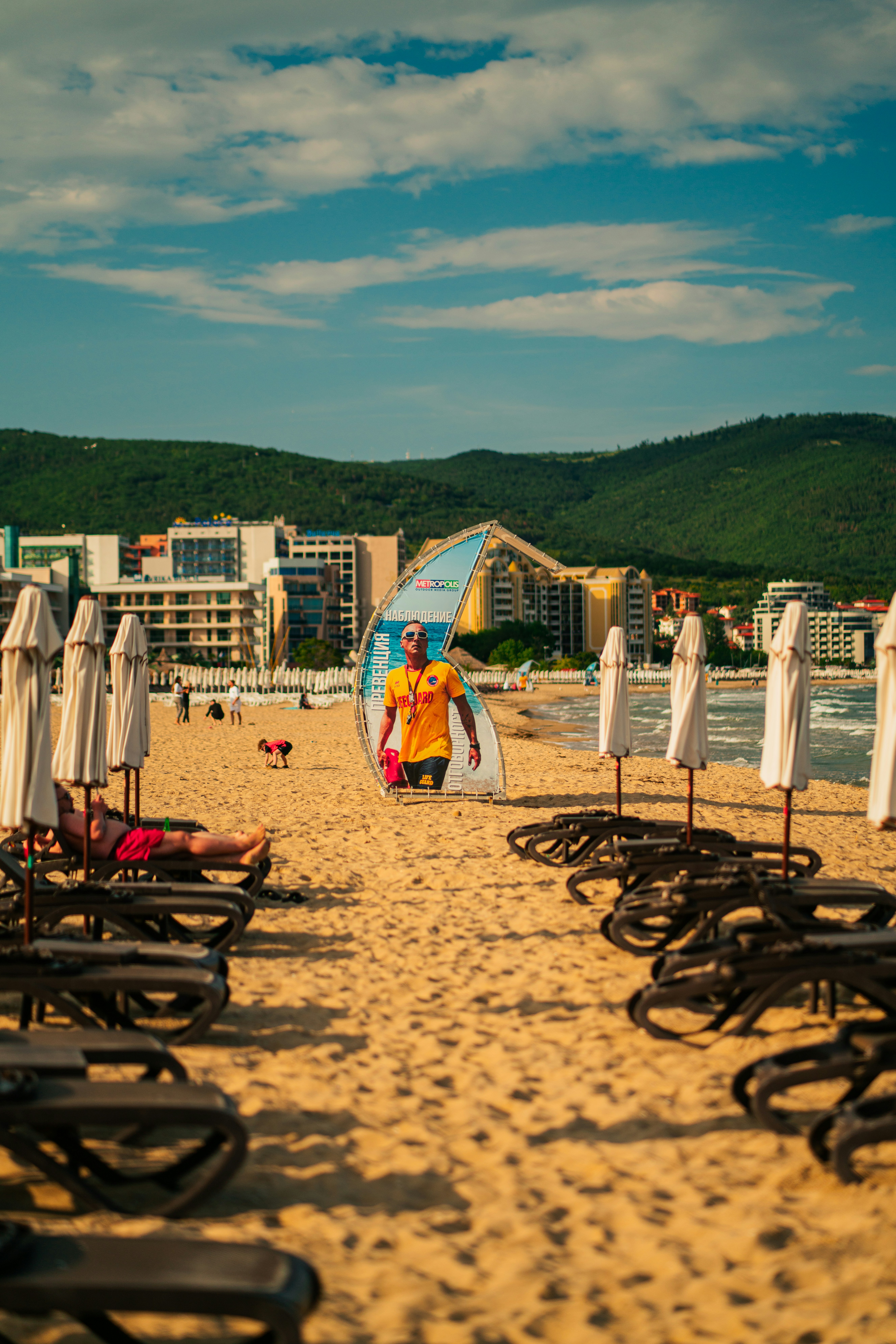 Una playa de arena con muchas sillas y sombrillas
