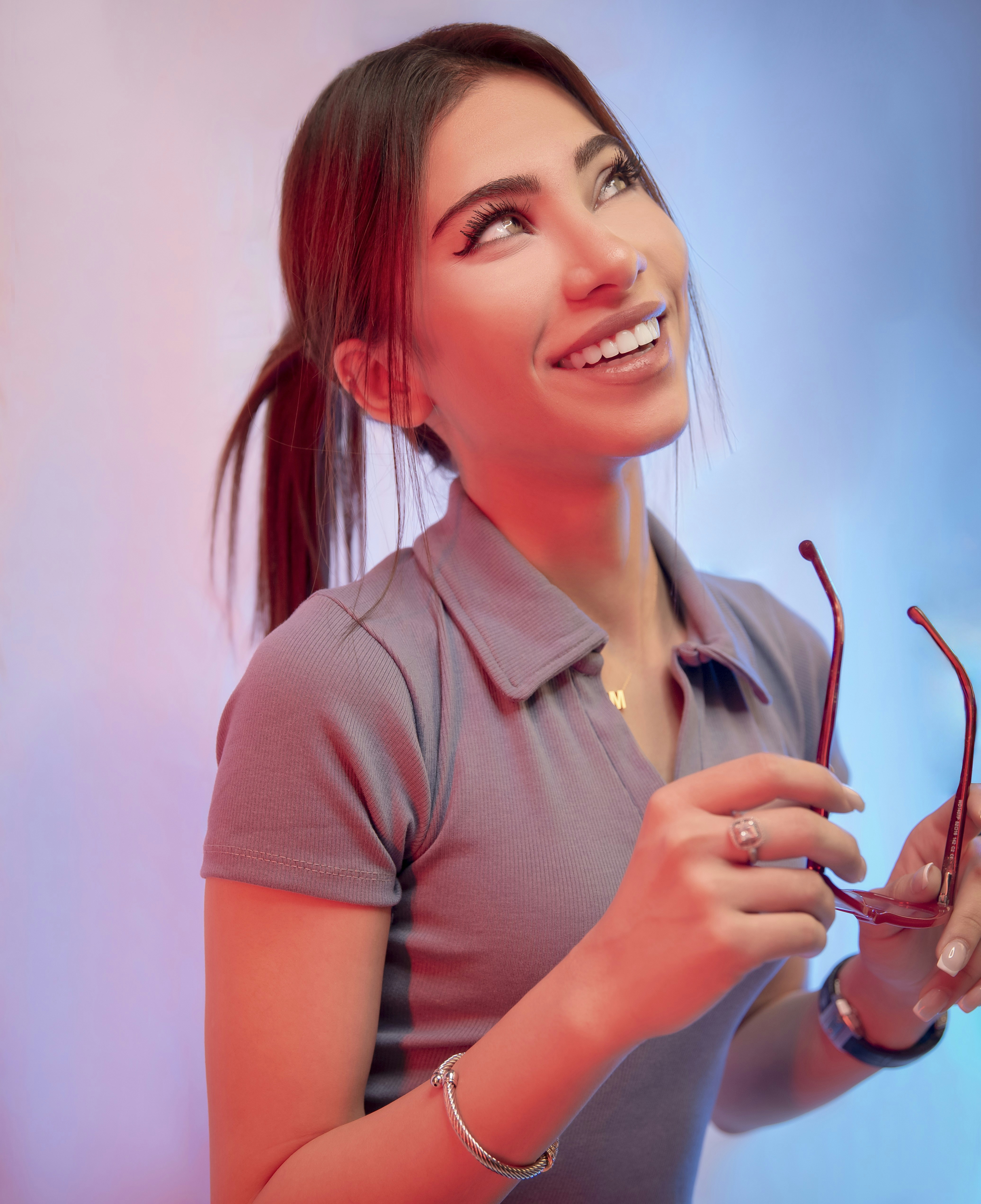 A woman holding a pair of glasses in her hands