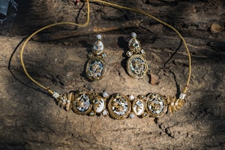 A necklace and earrings sitting on top of a rock