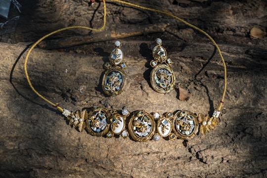 A necklace and earrings sitting on top of a rock