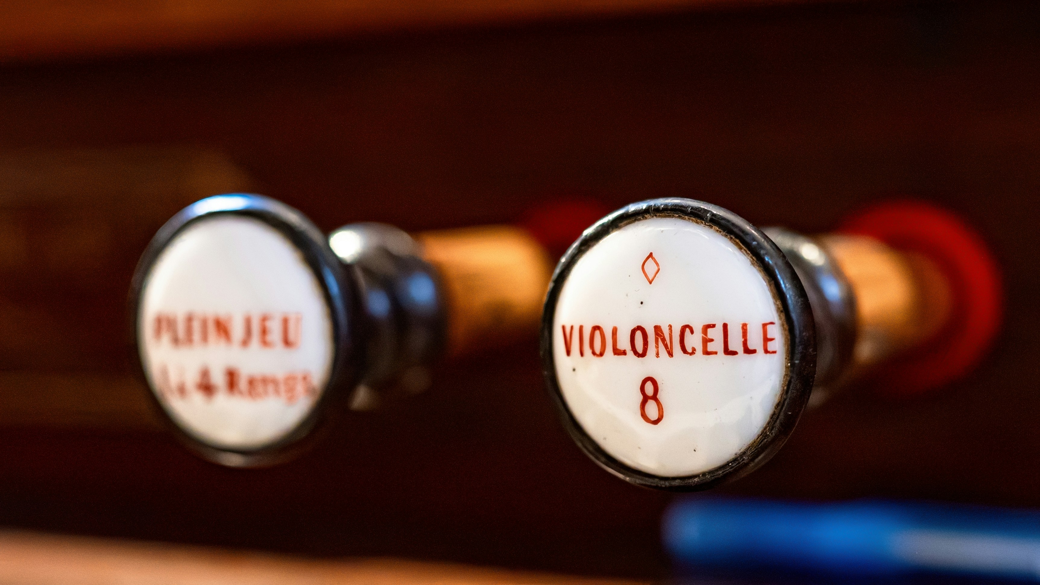 A close up of two knobs on a wooden cabinet