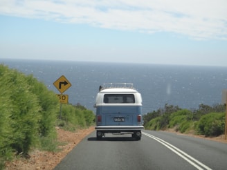 A van driving down a road next to the ocean