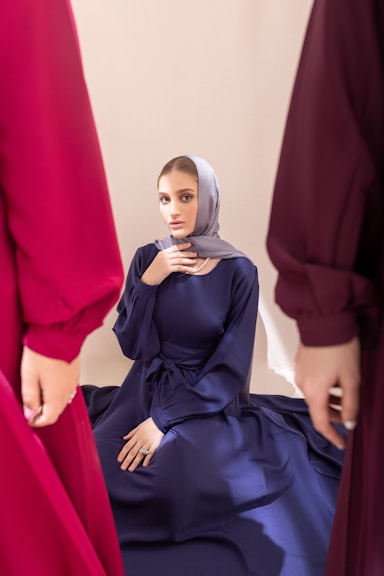 A woman in a blue dress sitting in front of a mirror