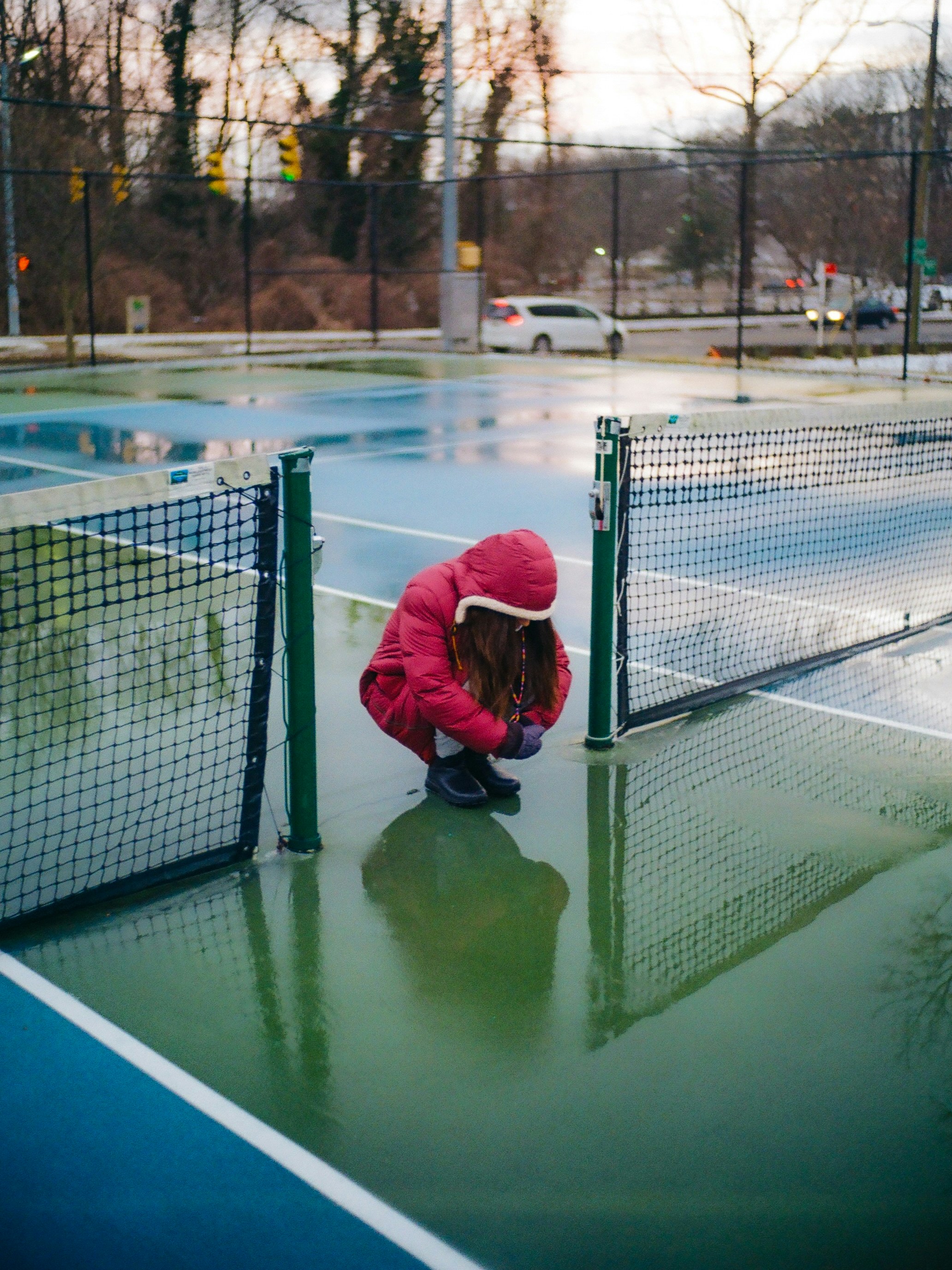 A person kneeling down on a tennis court