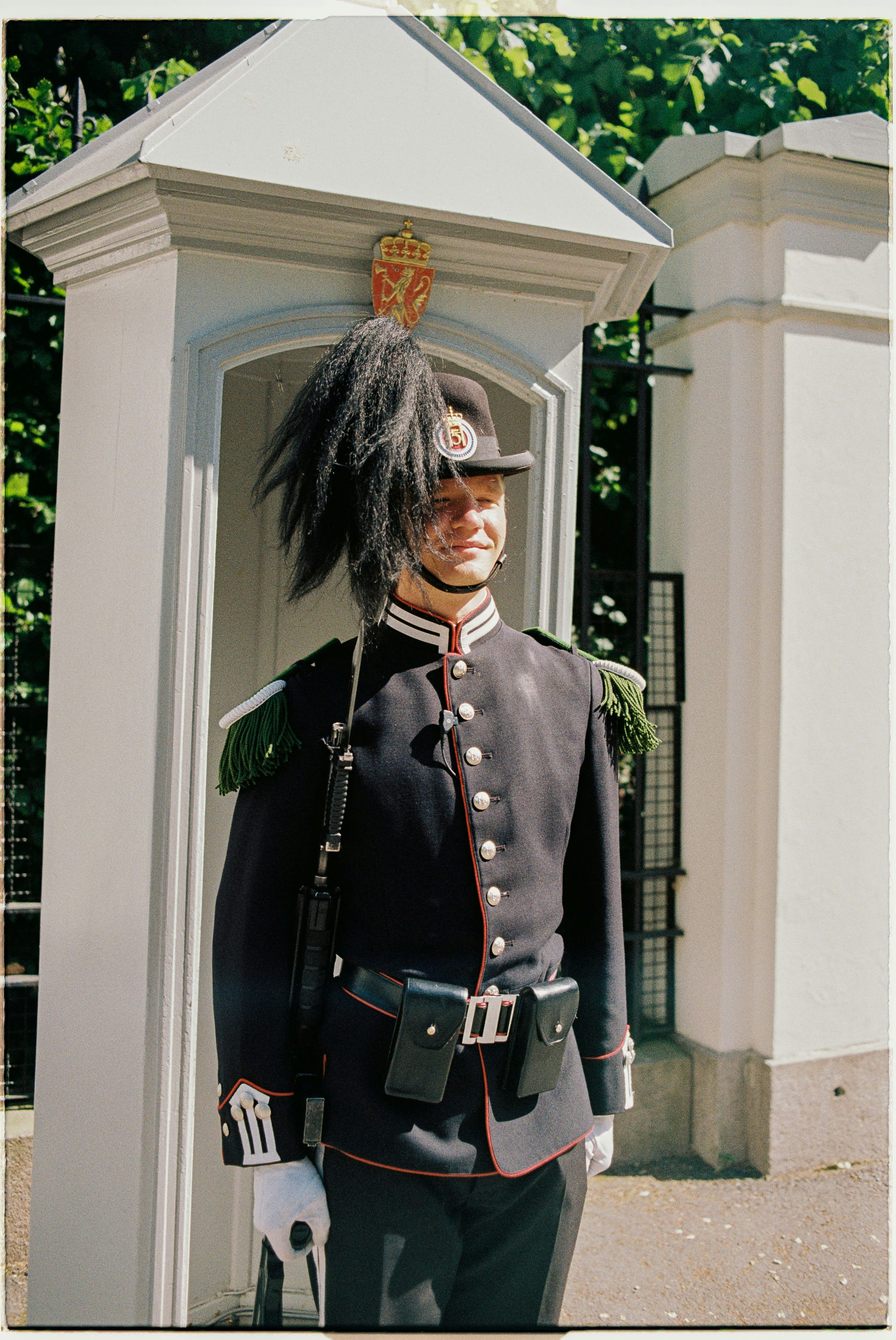 A man in a uniform standing in front of a white structure