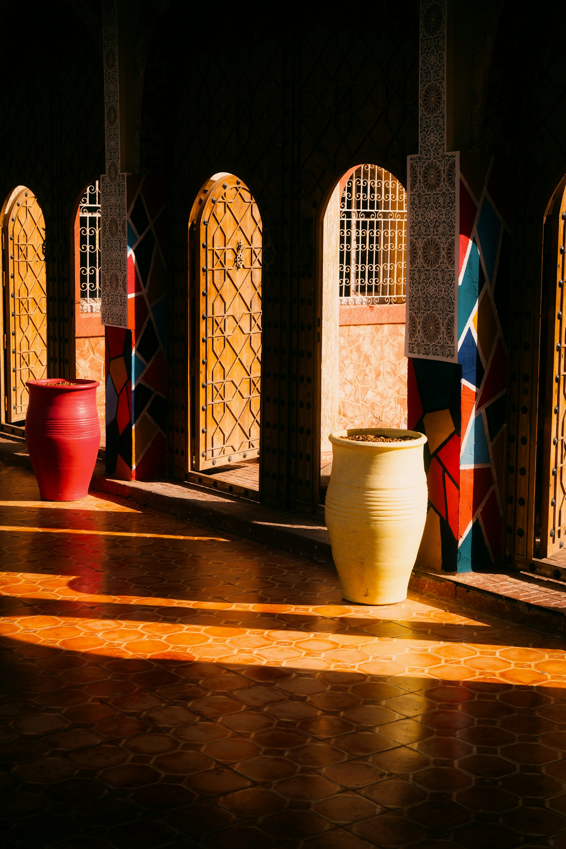 A row of vases sitting on top of a tiled floor