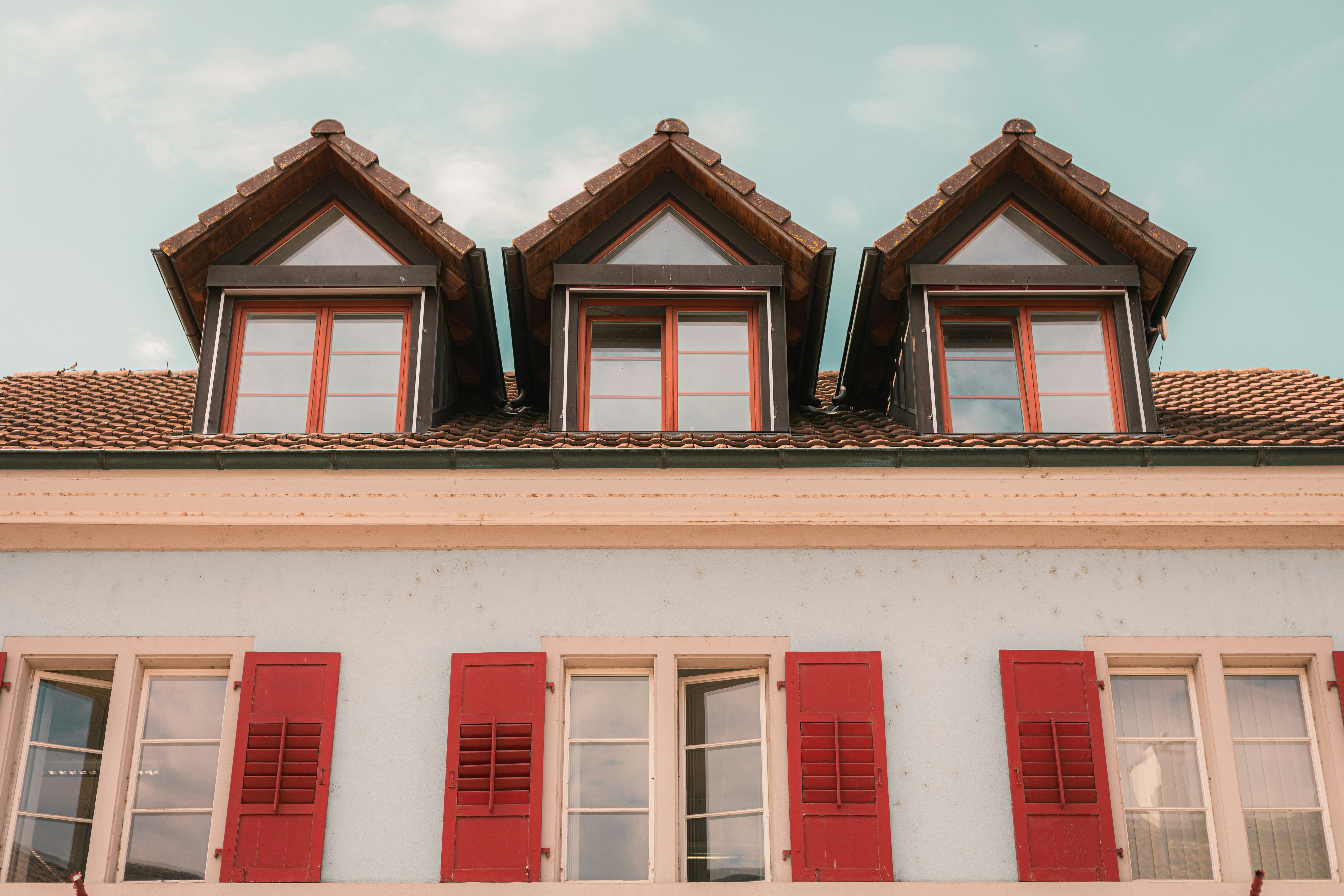 Un edificio con persianas y ventanas rojas