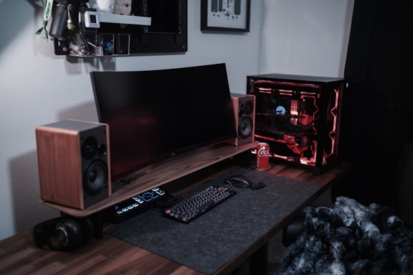 A desk with a laptop and speakers on it